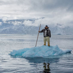 Picture of an Inuit man standing on ice in Uummannaq Fjord on Greenland's west coast