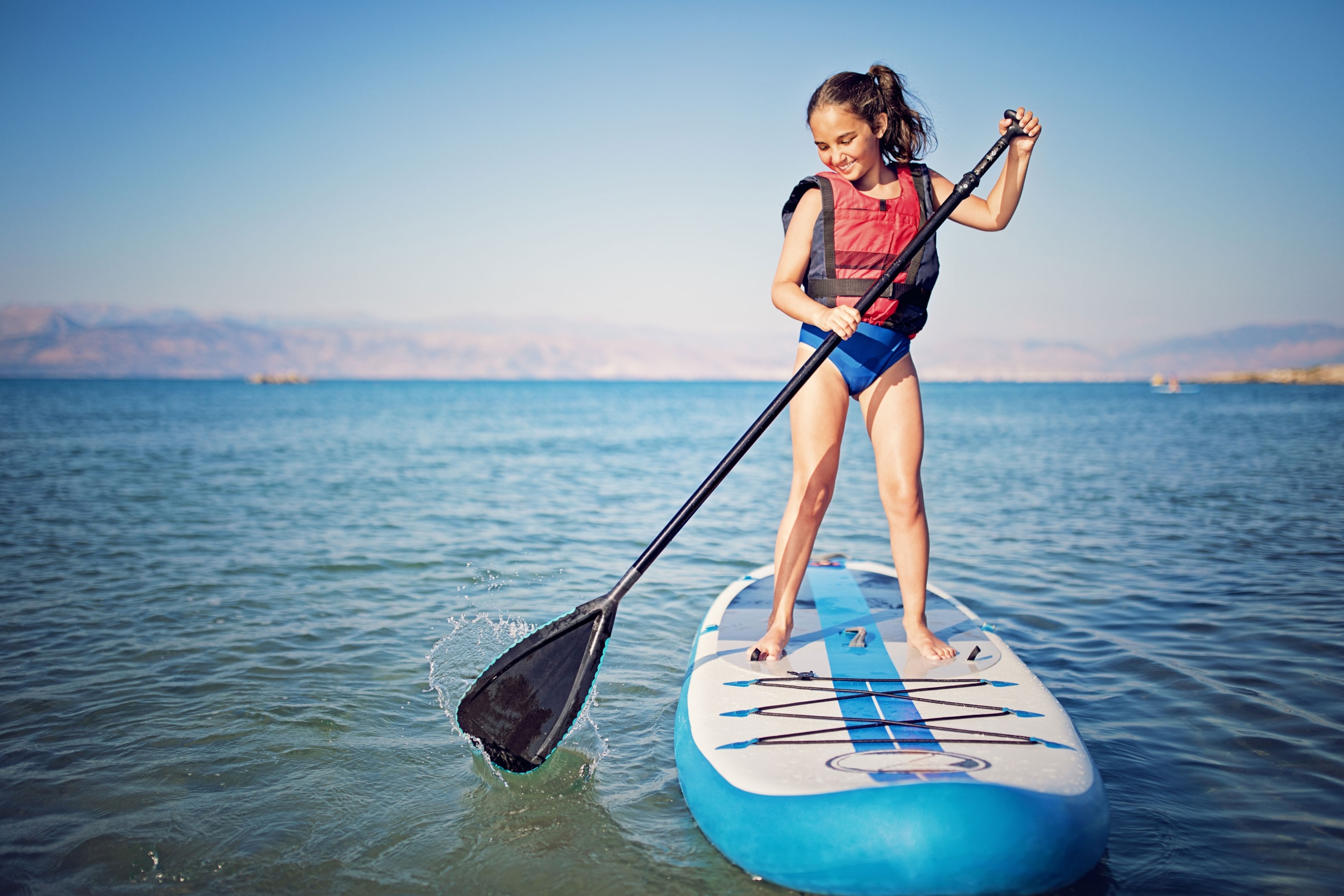 Little girl on paddle board in the ocean