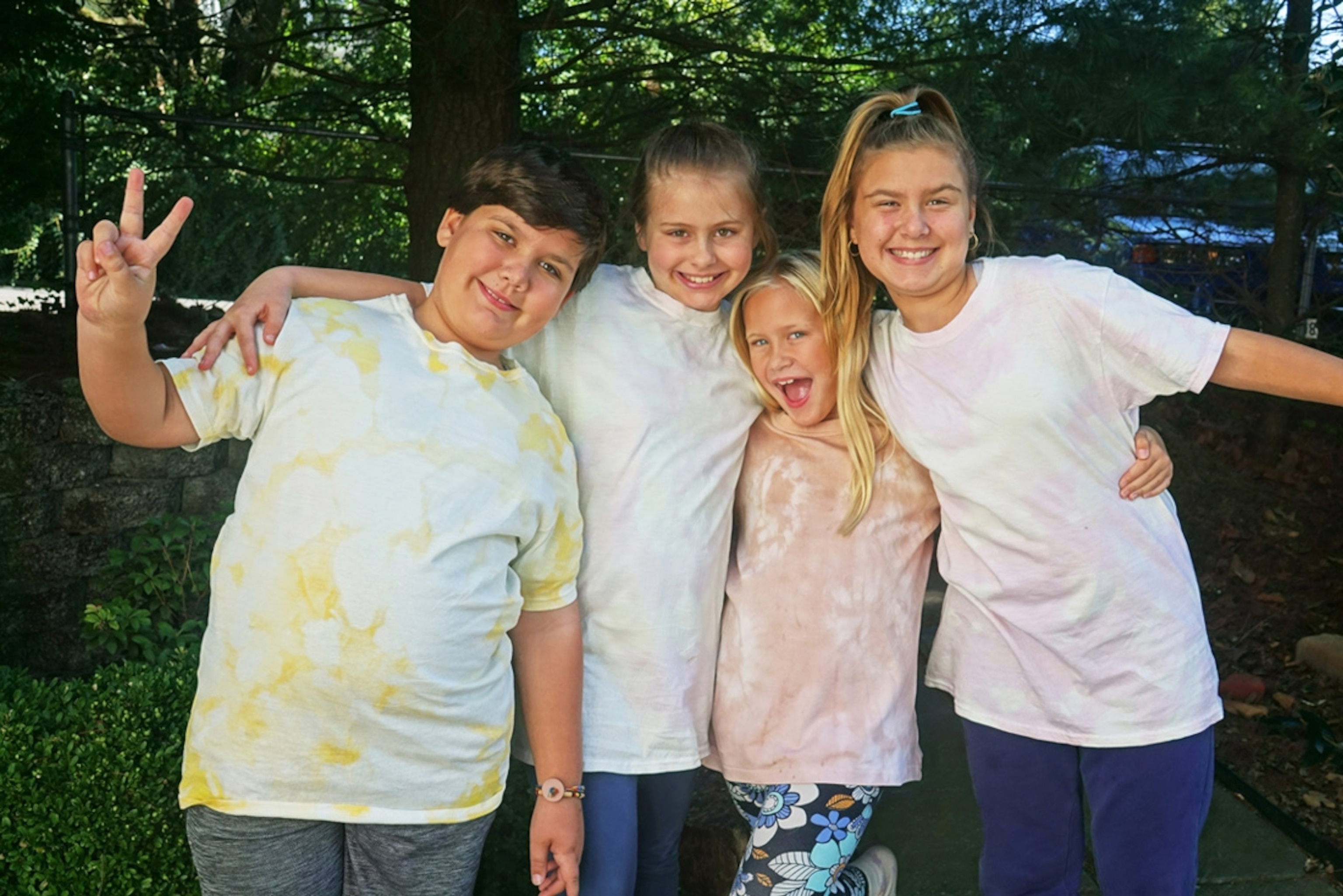 A group of kids wearing shirts tie-dyed with various foods.