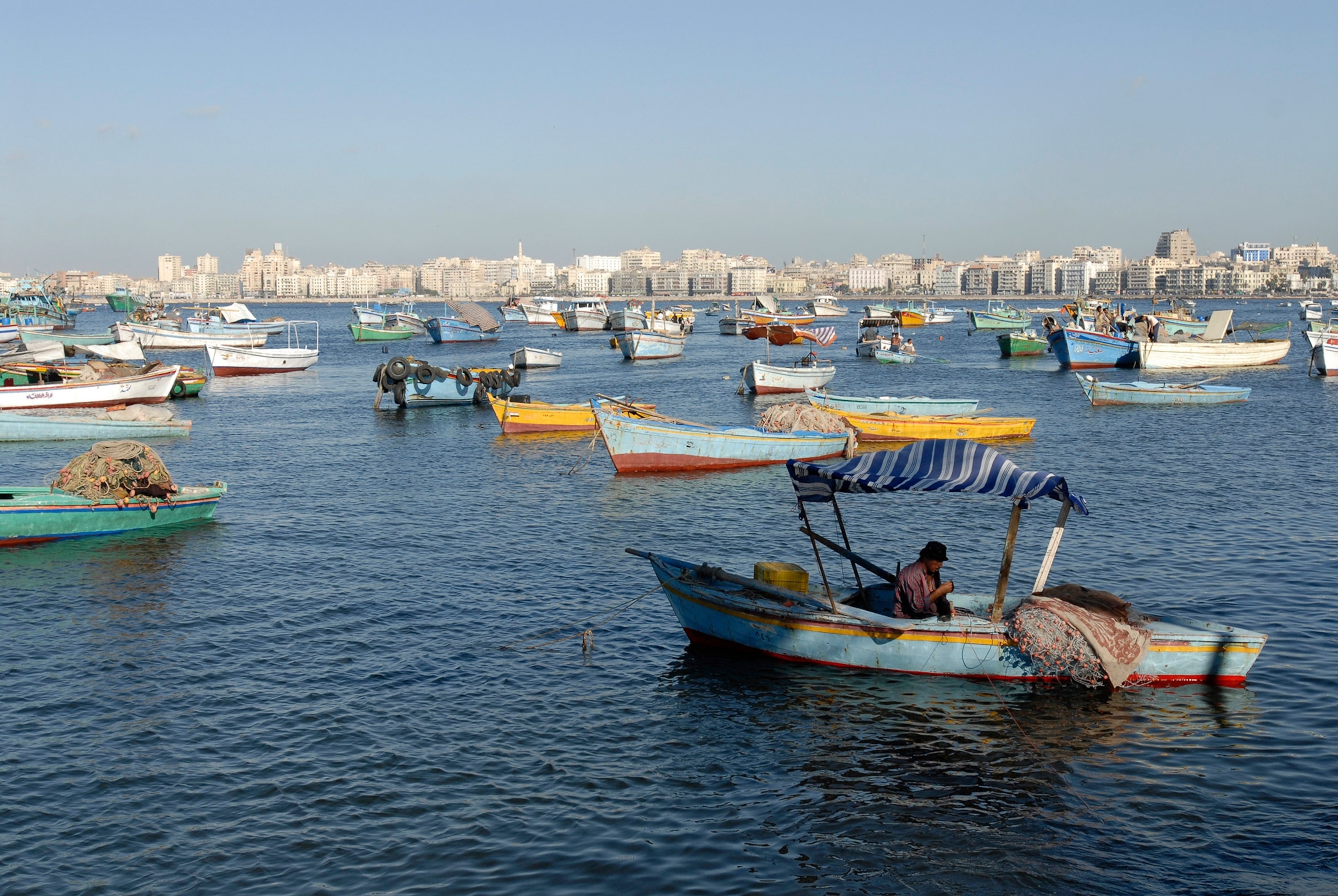 a fisherman working on his nets in the Eastern Harbor of Alexandria, Egypt