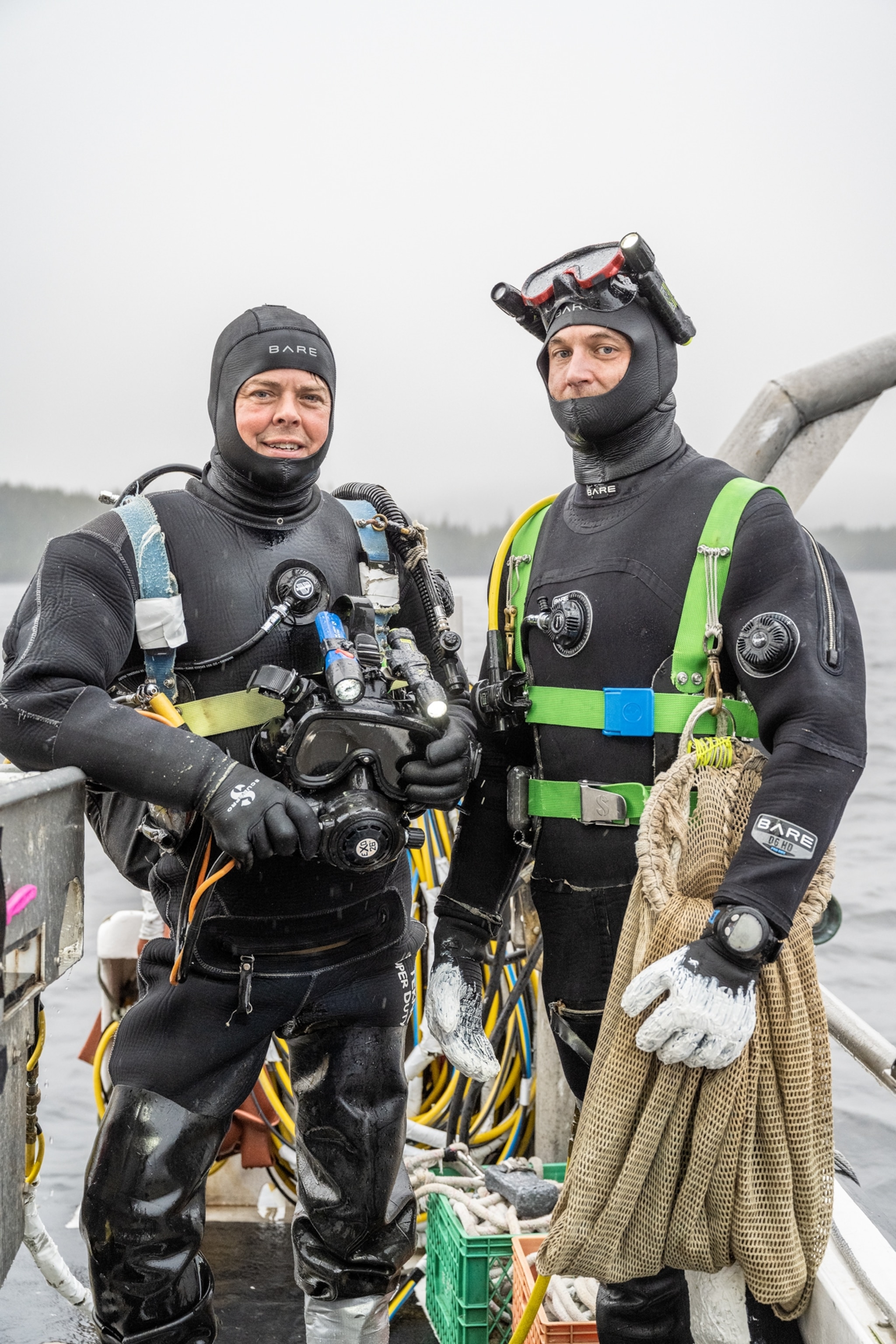 Picture of two men standing on a boat in full diving gear.