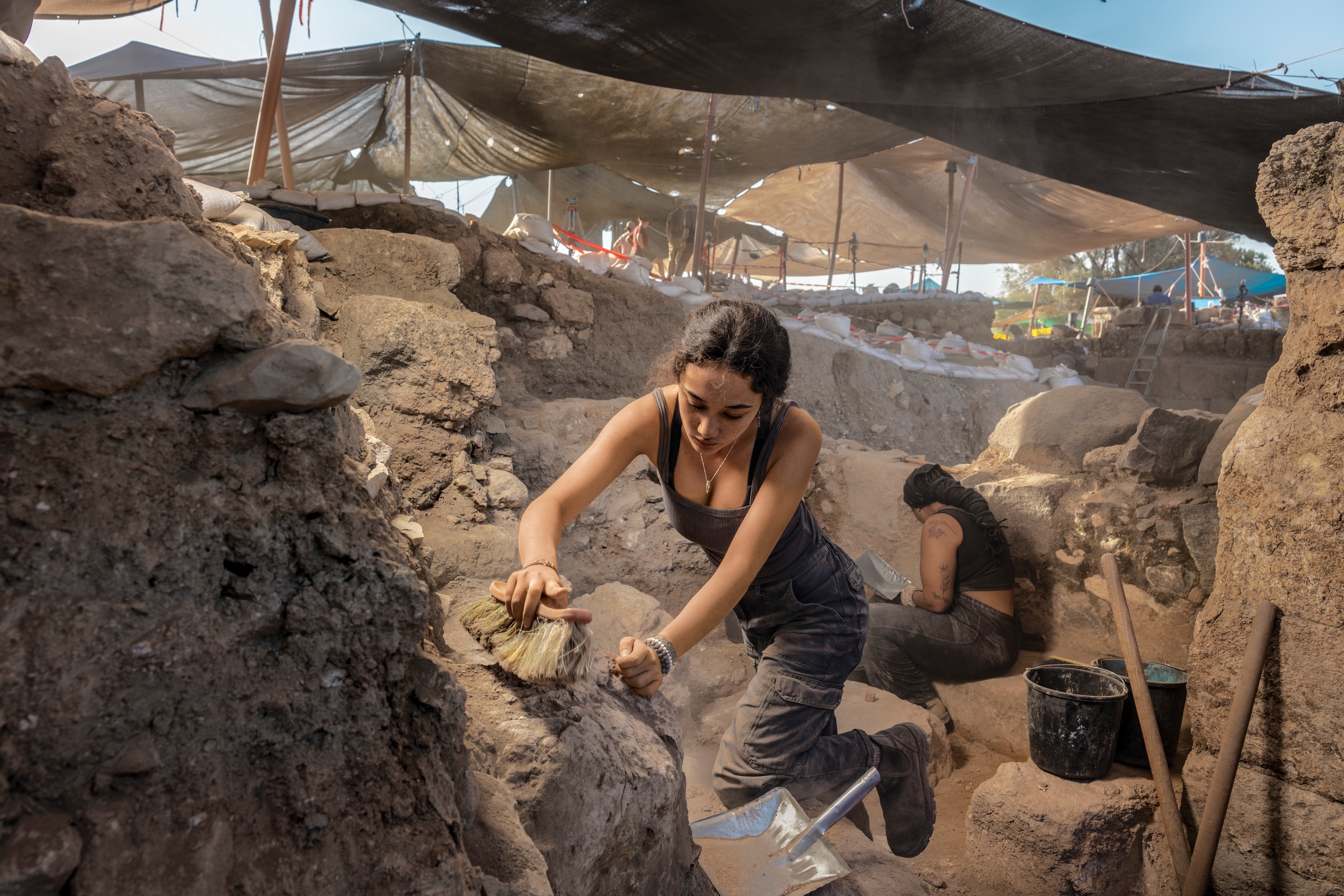Anna is brushing off stone to reveal mosaics.