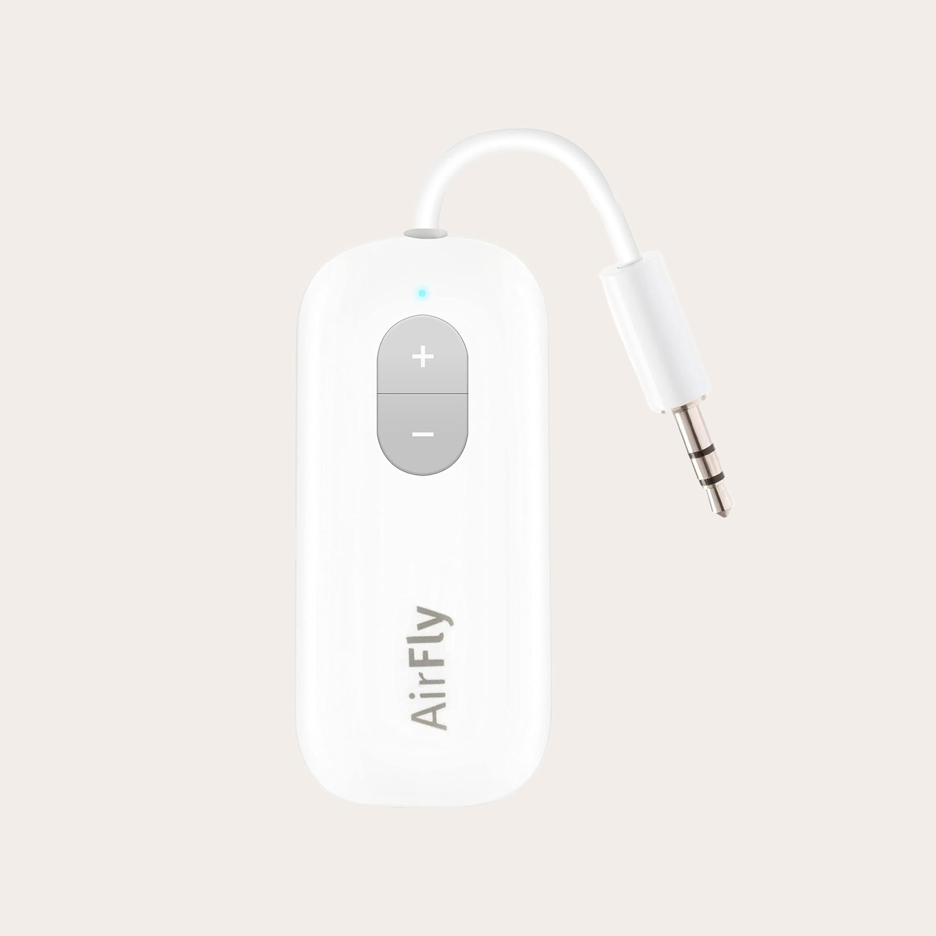 Small white headphone adapter placed on a tan background.