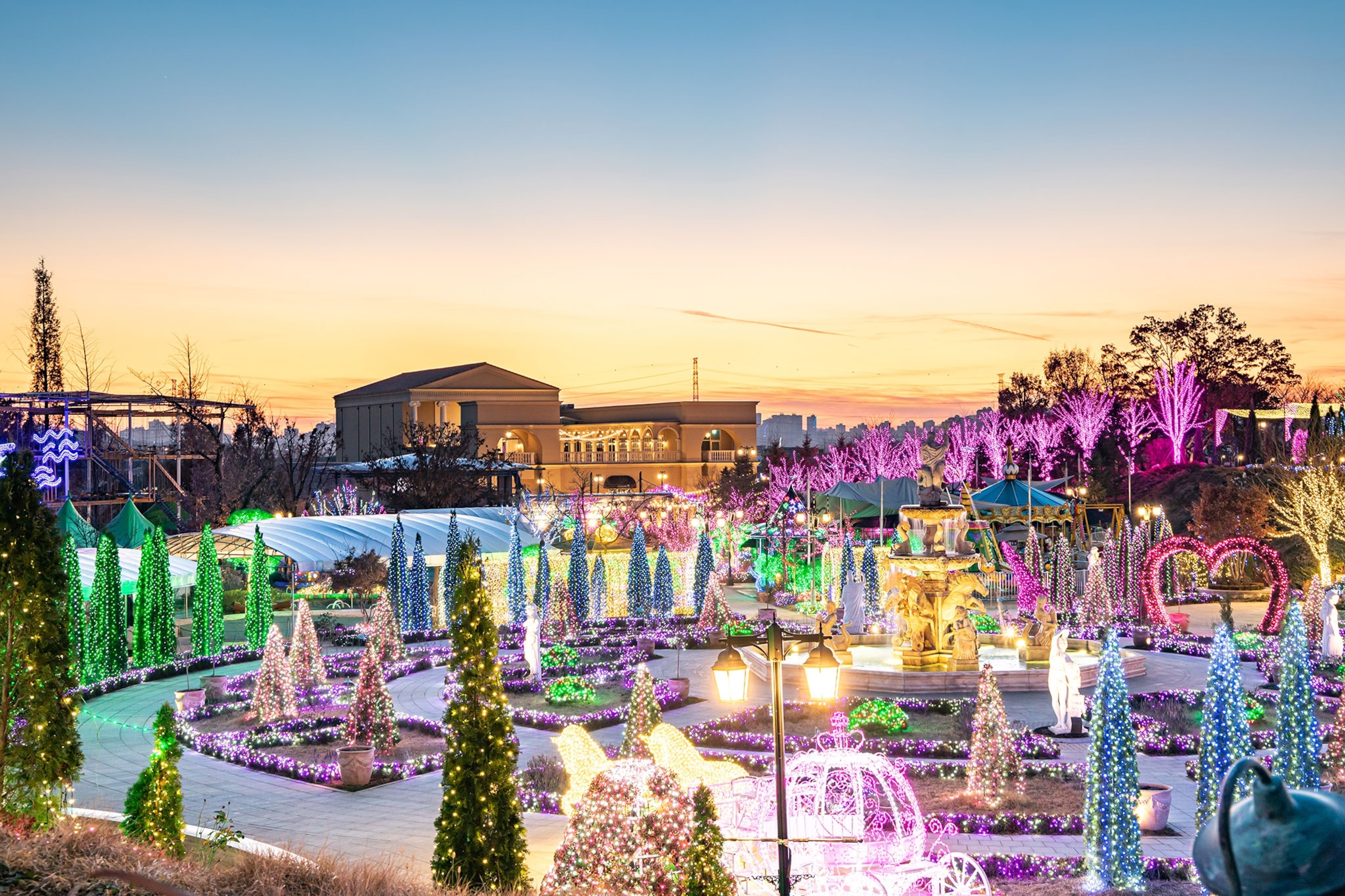 Multi-coloured lights glow across the garden at dusk.