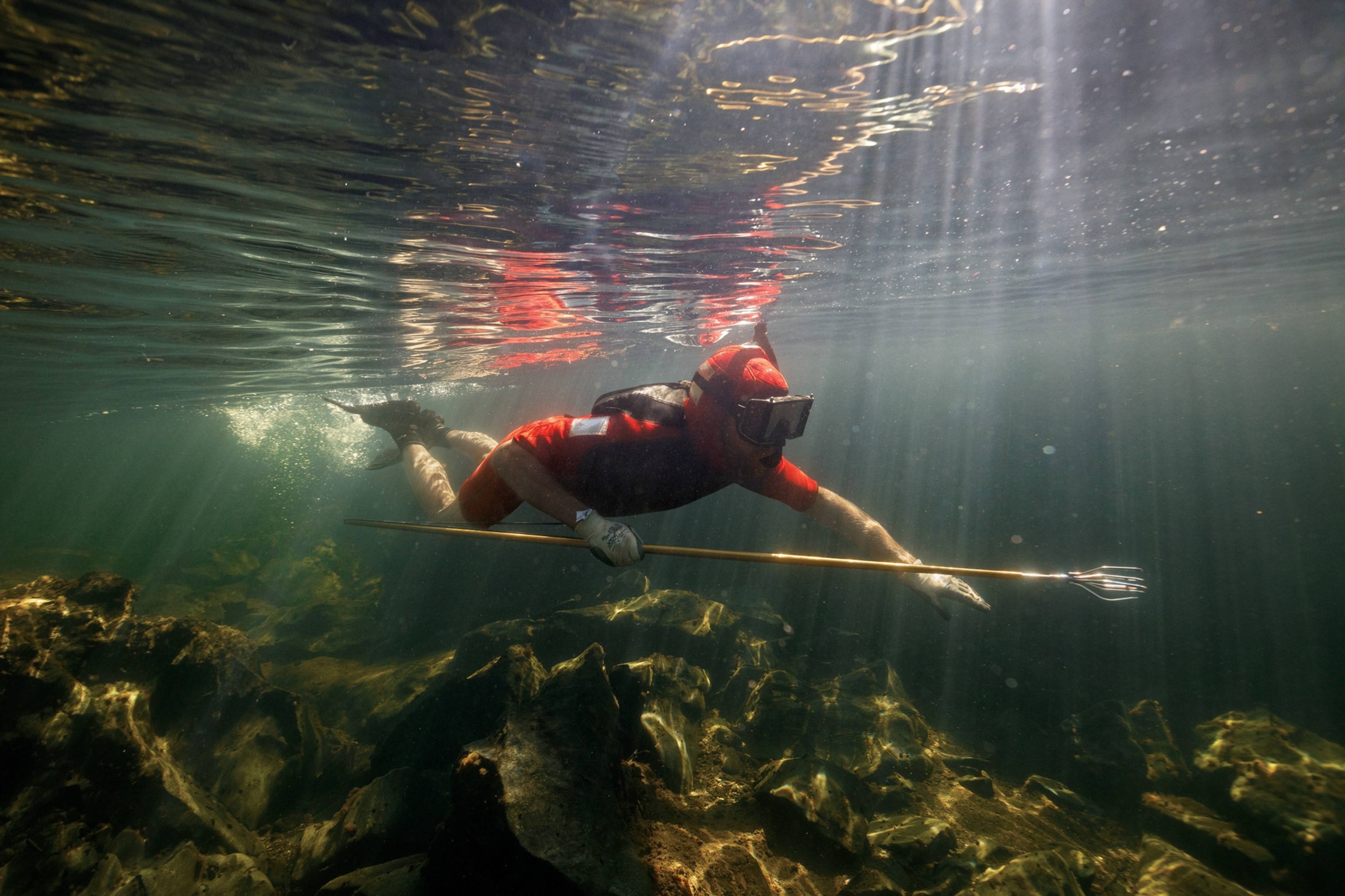 Picture of Joseph Metzler underwater with a fishing spear in his hand.