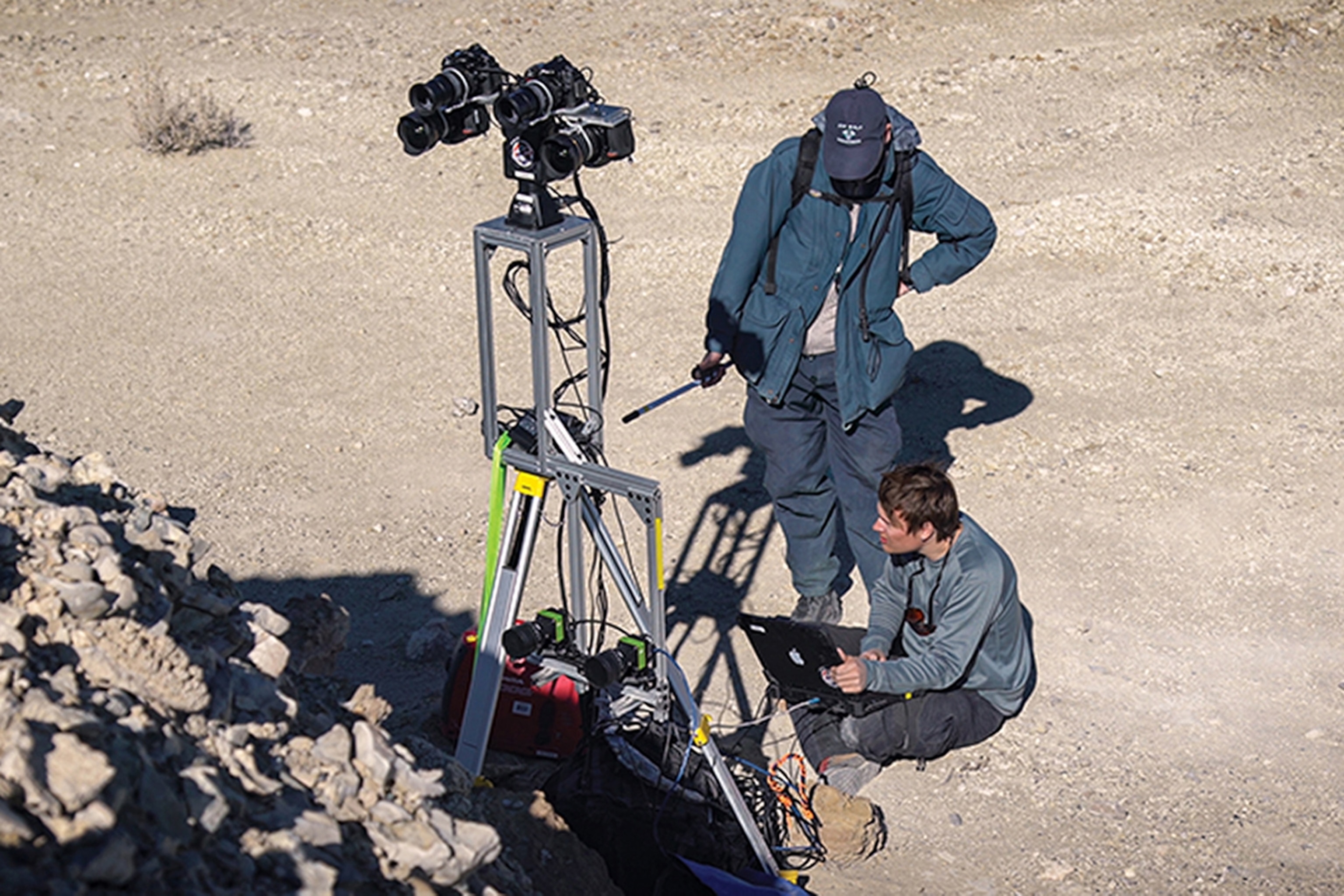 two men setting up the cameras in desert.
