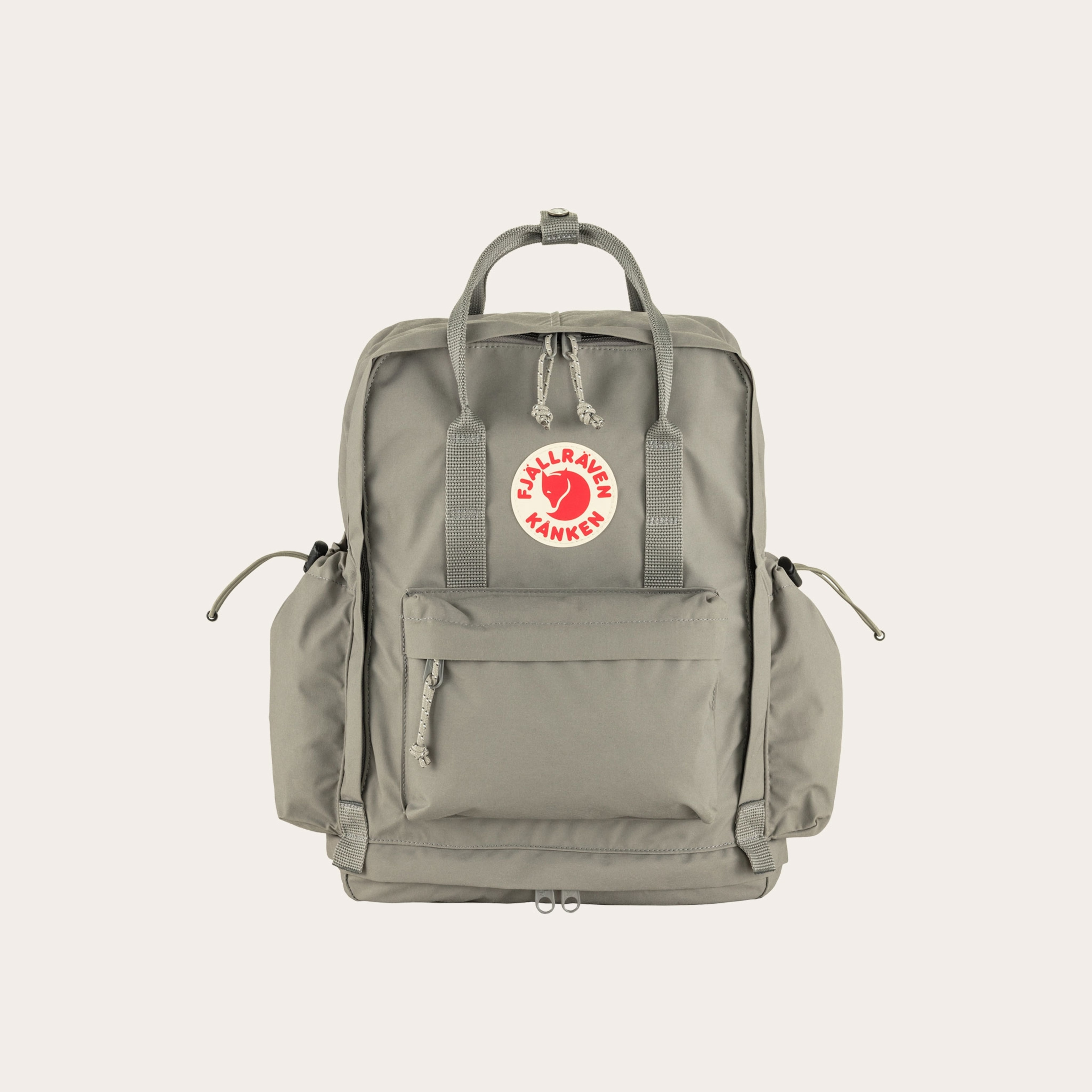 Grey backpack with a red and tan logo placed on a tan background.