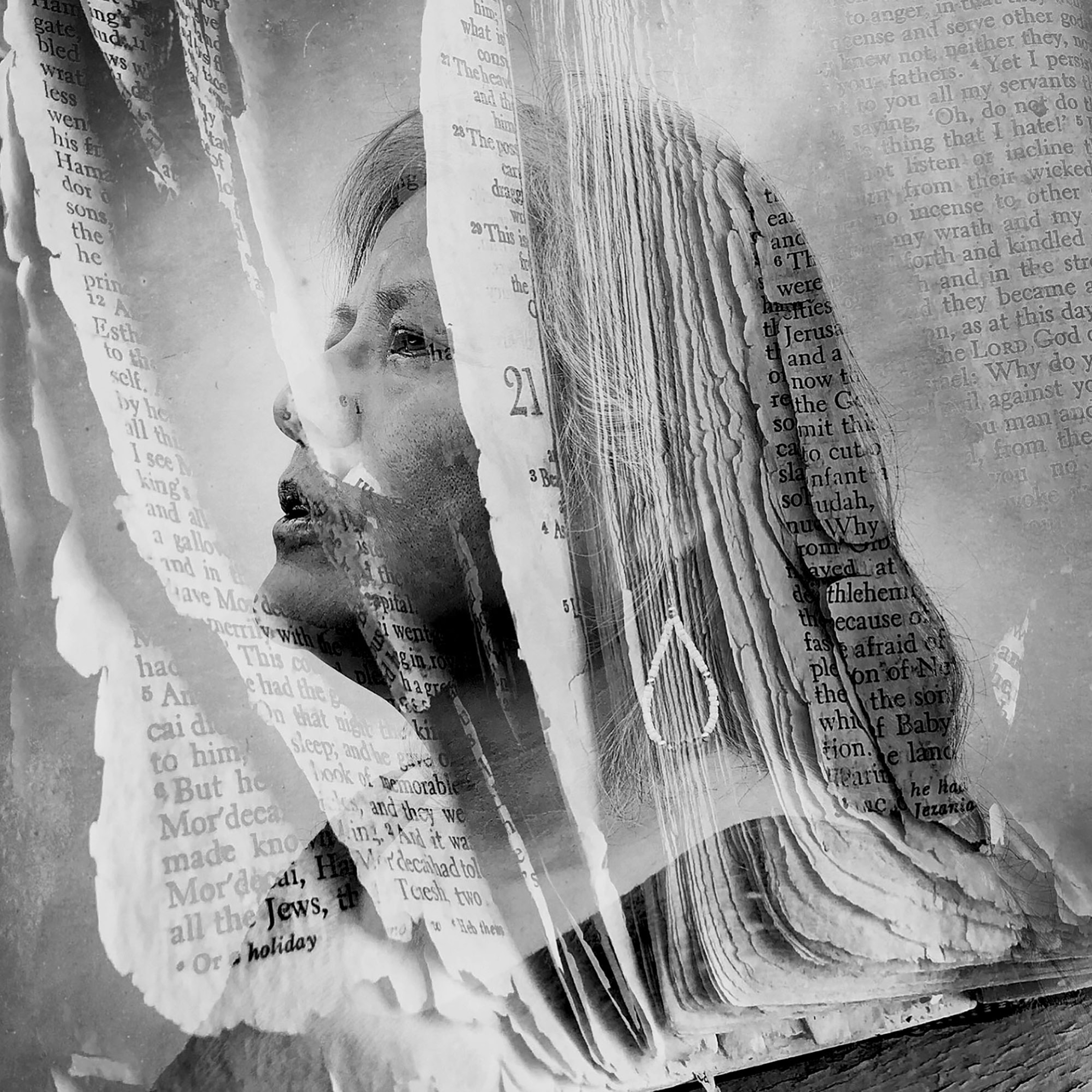 Picture of b&w photo of woman's face seen through open book pages.