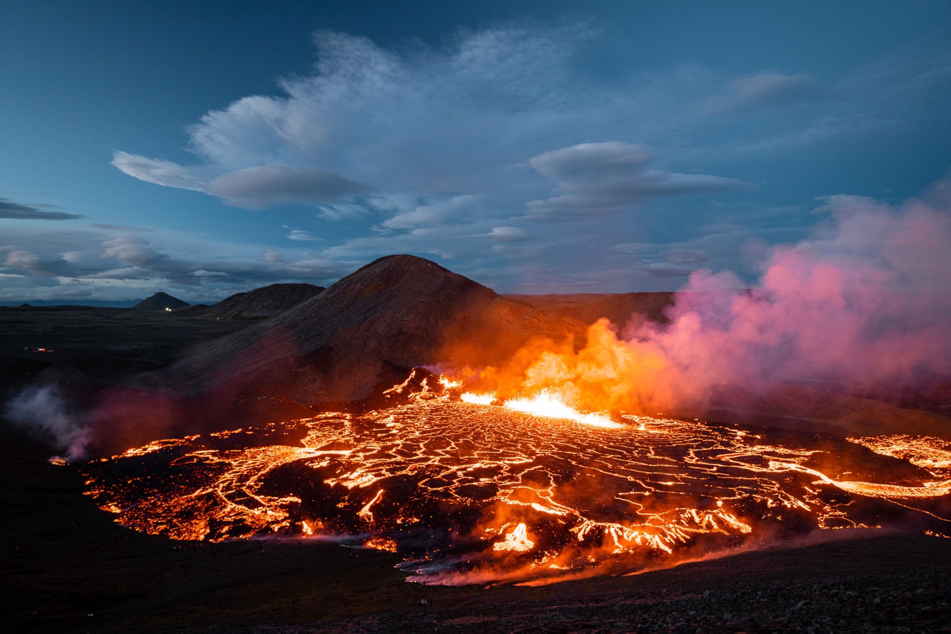 volcano erupting against a dark blue sky