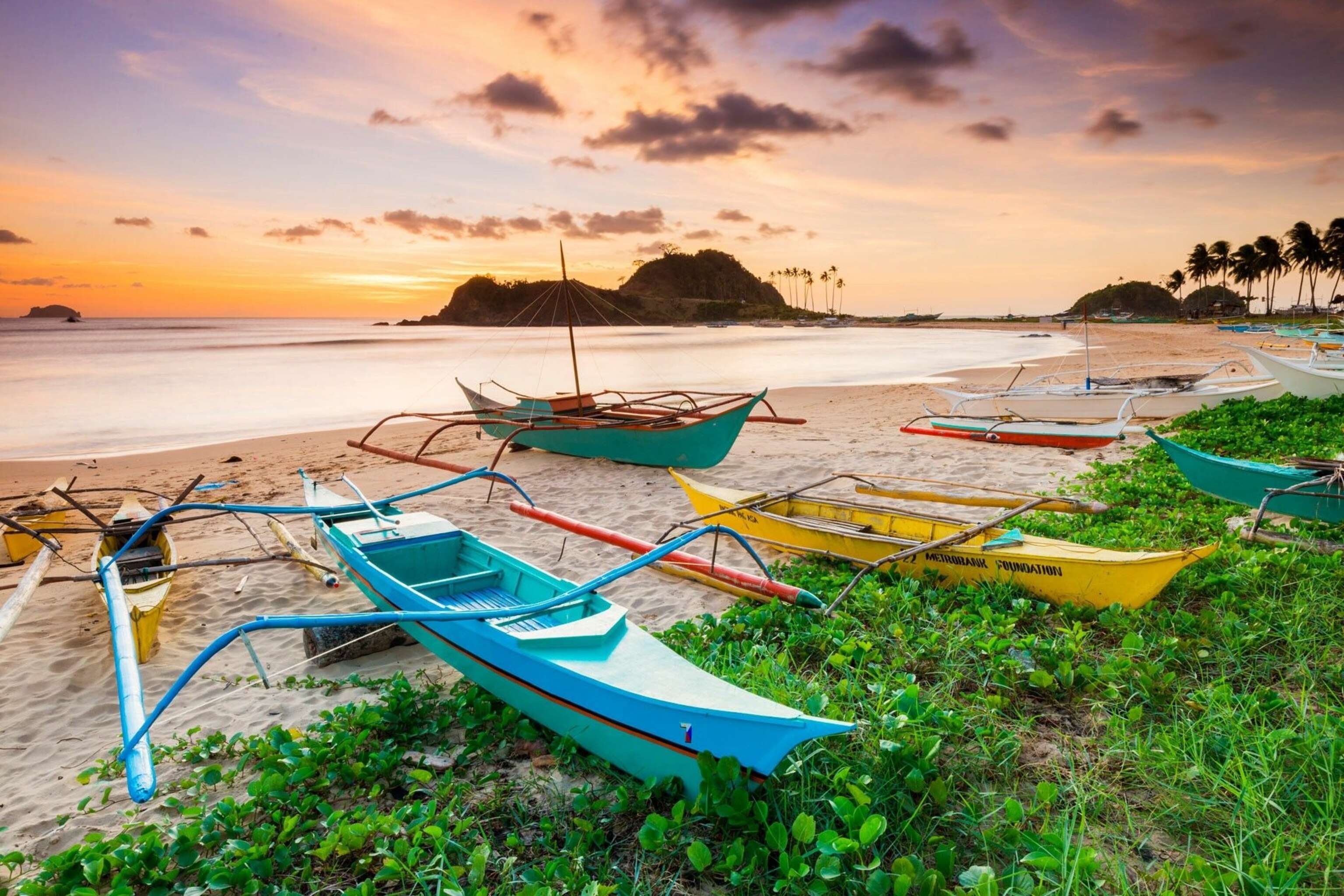 Traditional bangka boats on Nacpan beach in Palawan. They look like kayaks, but have flat rectangular frames mounted perpendicularly to the hull.