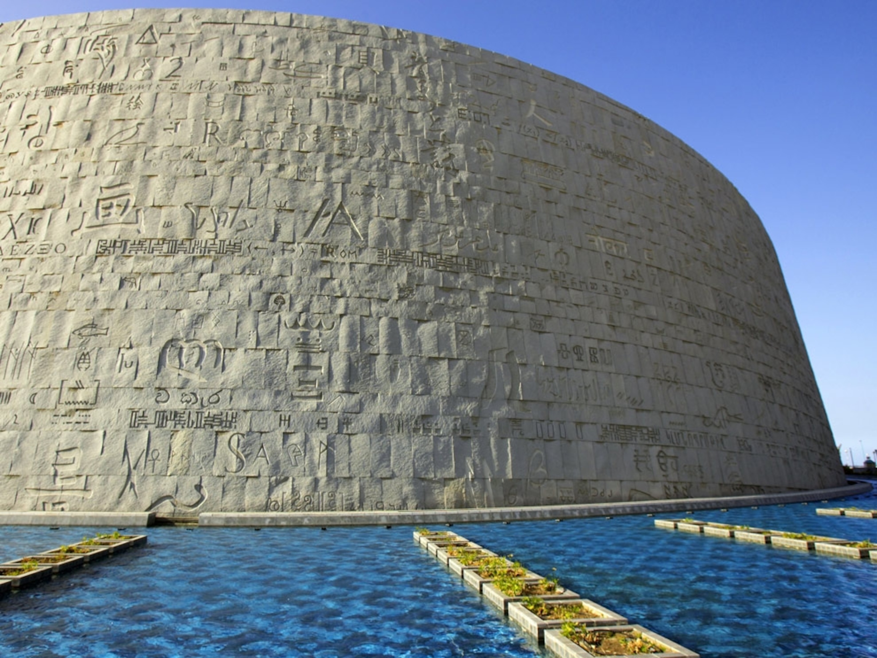 A wall with hieroglyphs surrounded by water