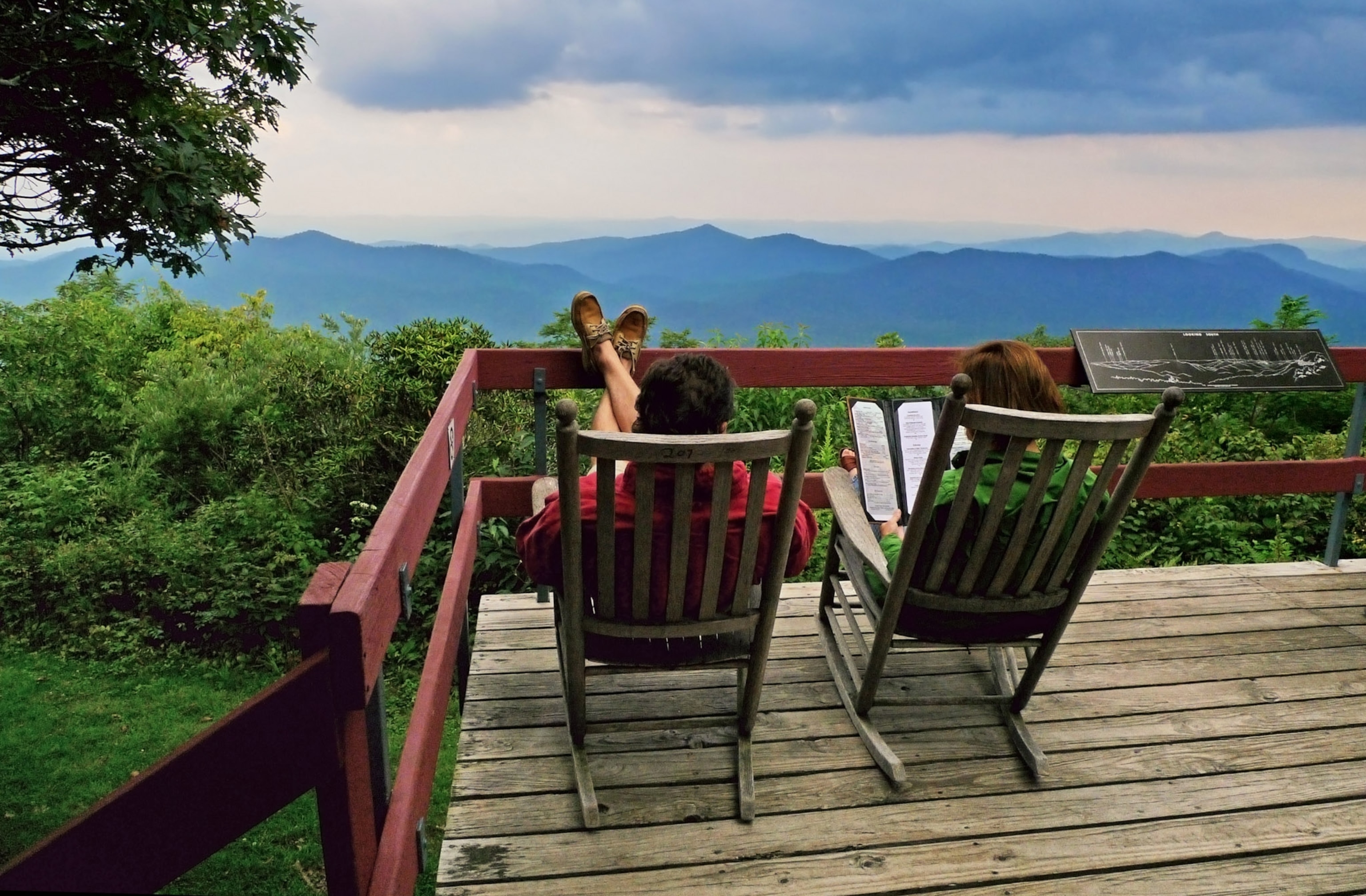 People in in chairs looking out at a scenic view.