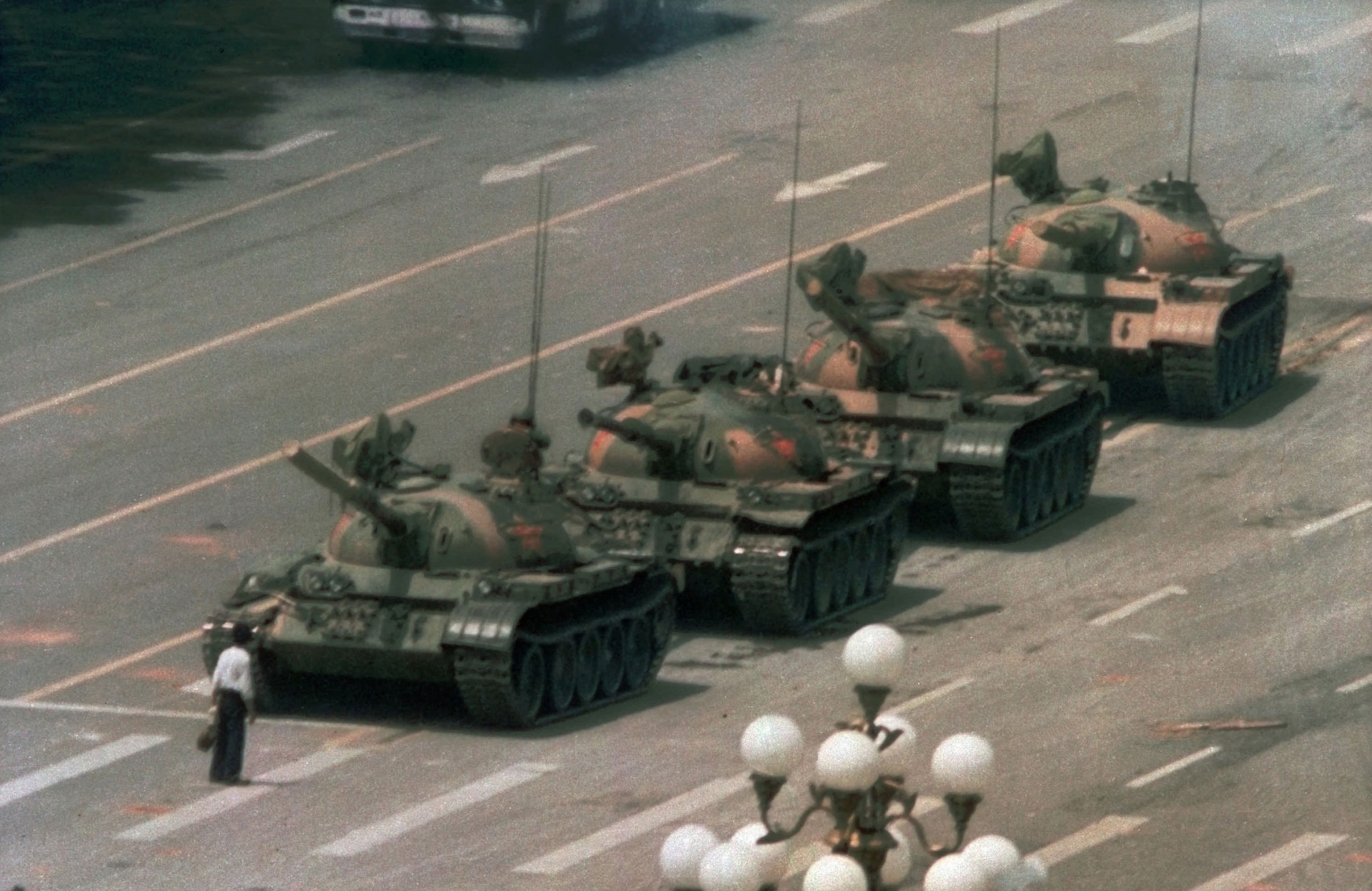 a man standing in the way of a row of tanks