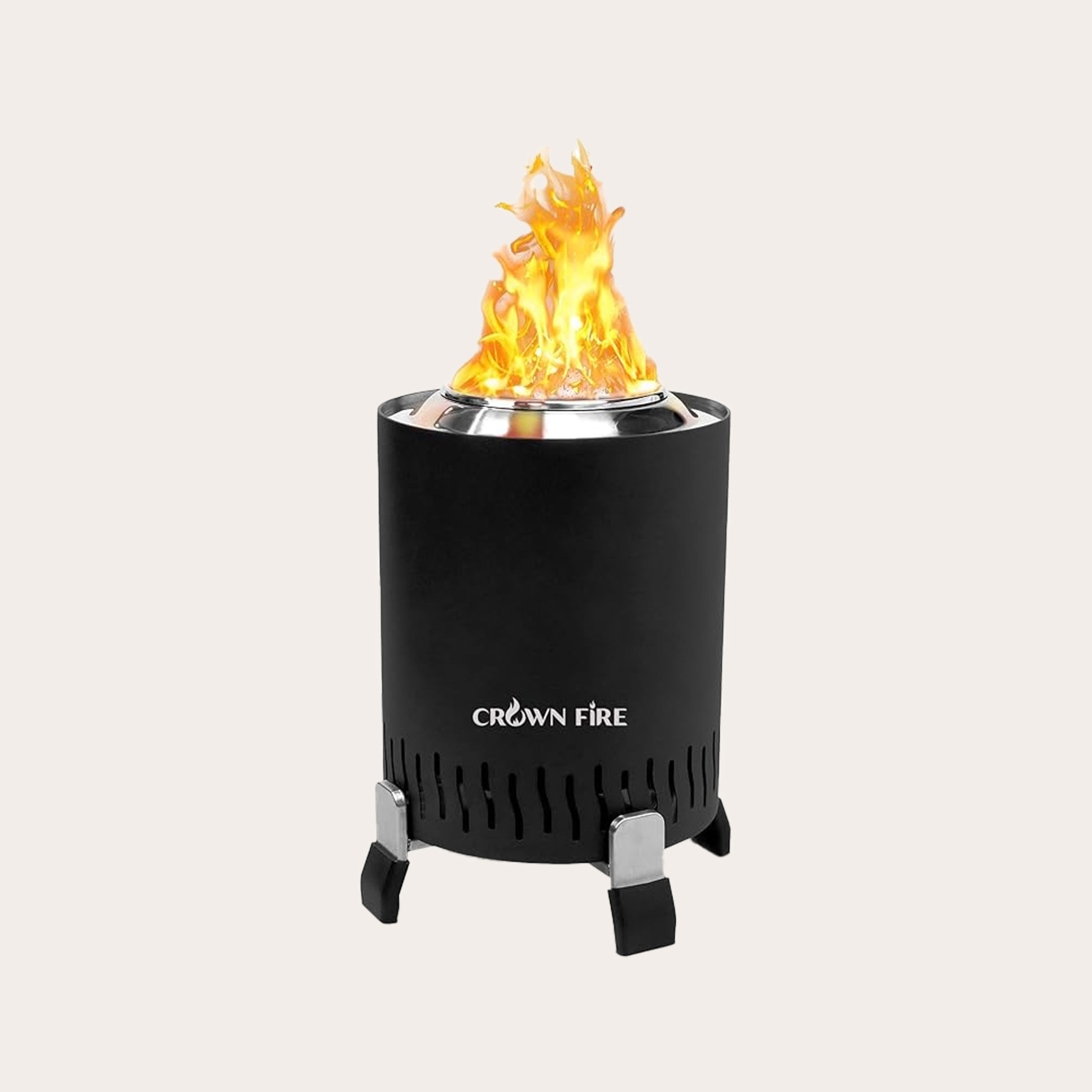 Black cylinder-shaped fire pit with legs and flames coming out of top placed on a tan backdrop.