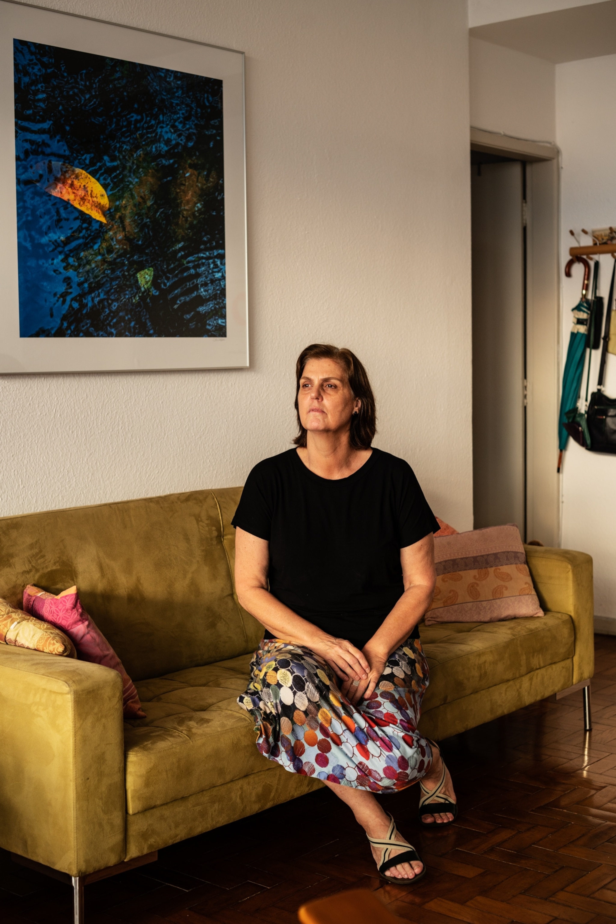 an older woman sitting on a yellow couch