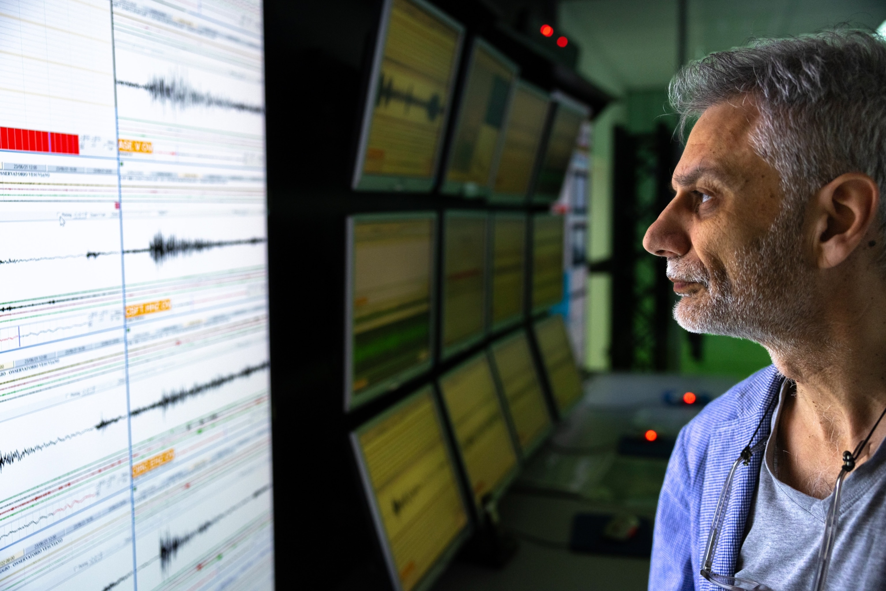 A technician examining seismic readings on monitors.
