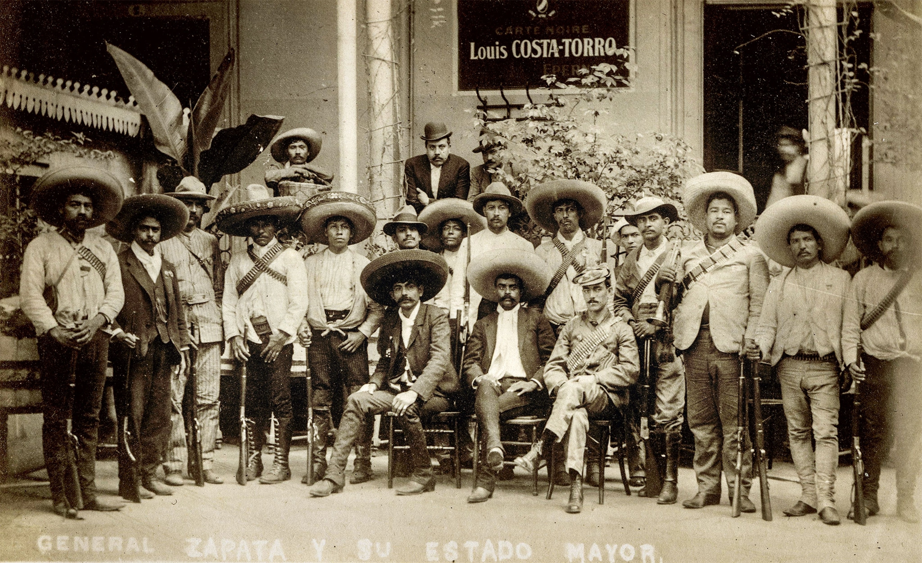 A photograph of Zapata seated in the center of his group of allies