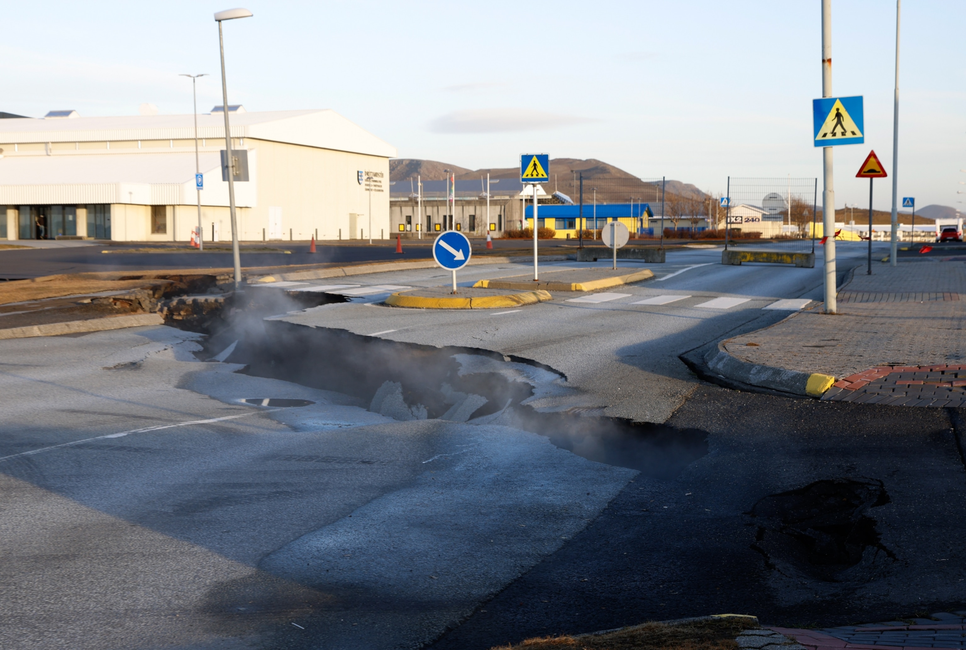 Steam rises from a fissure in a road near the town of Grindavik