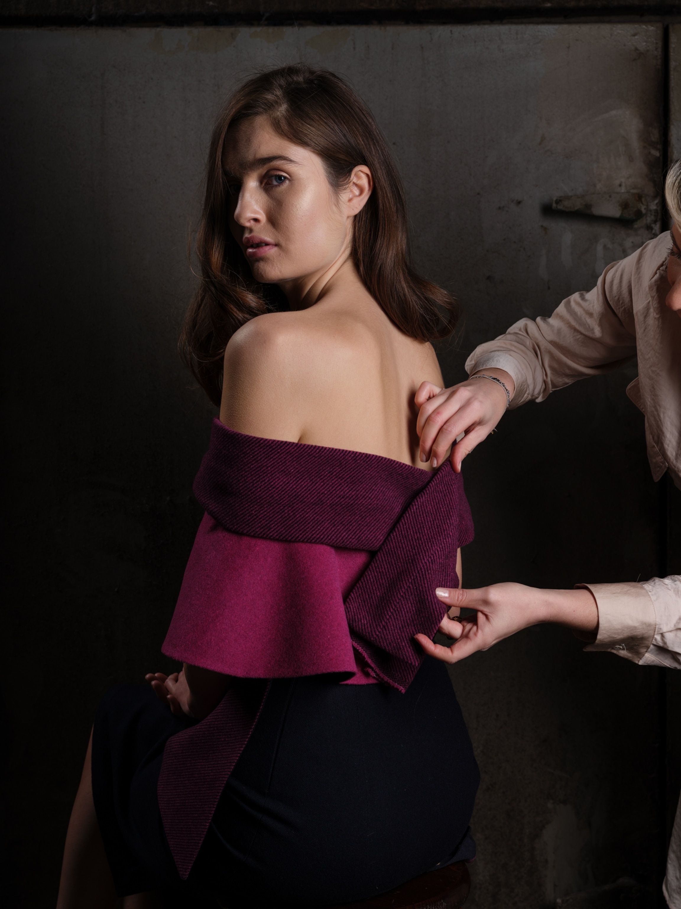 A designer adjusts a dress on a model