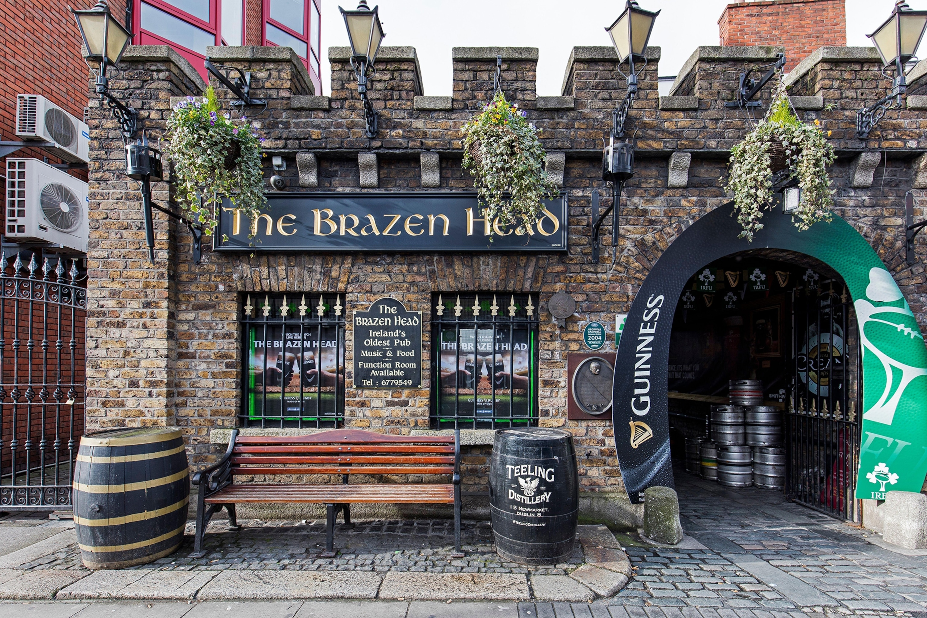 Exterior of a historical pub with stone walls and a bench stood outside