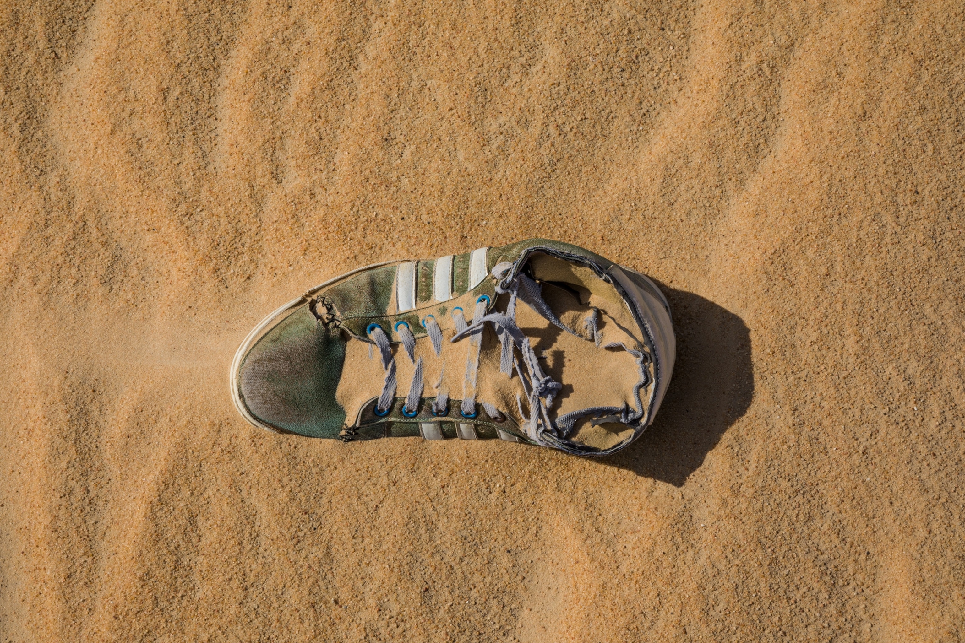 of an tennis shoe engulfed by sand
