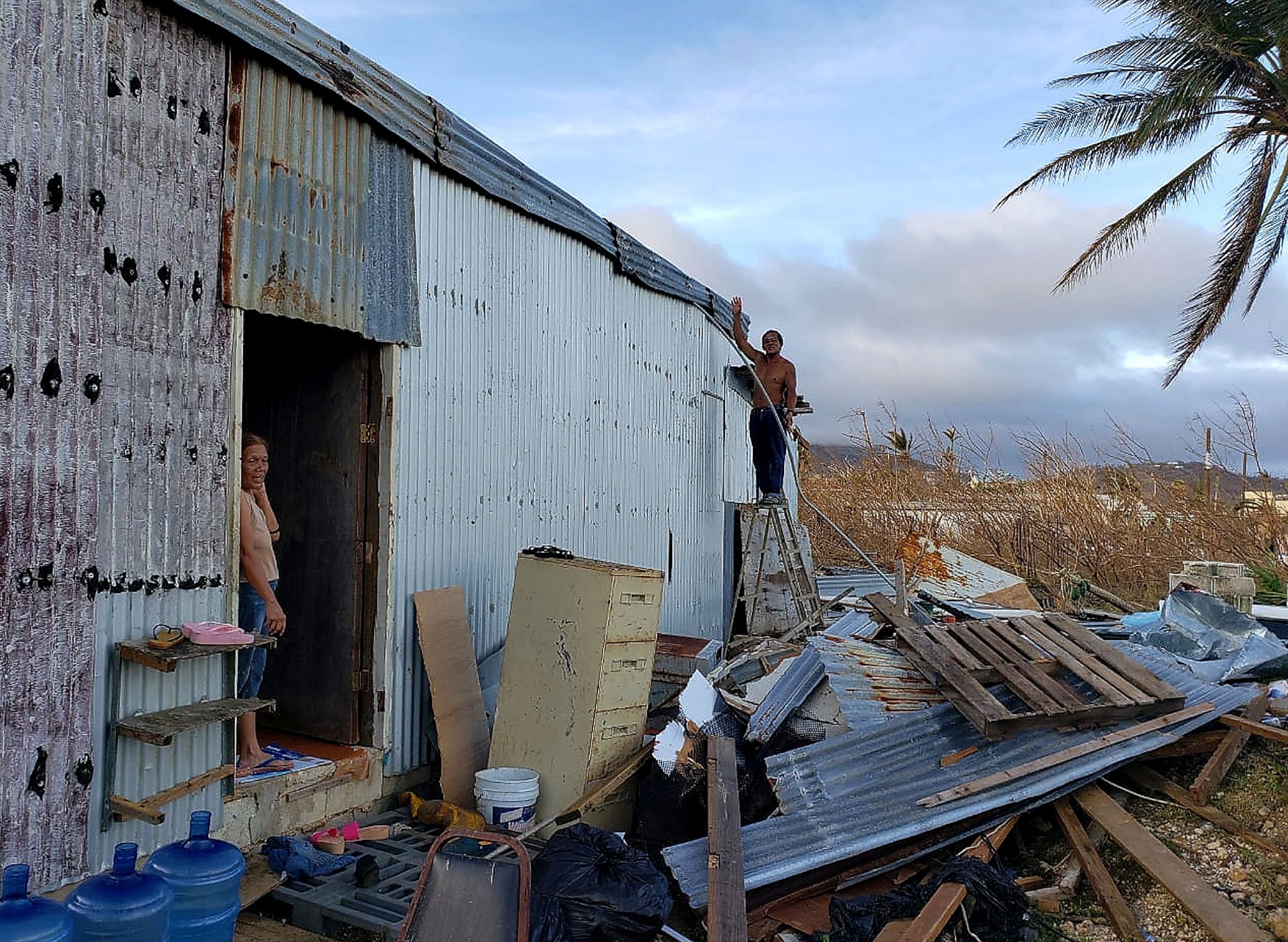a man repairing his home after a typhoon
