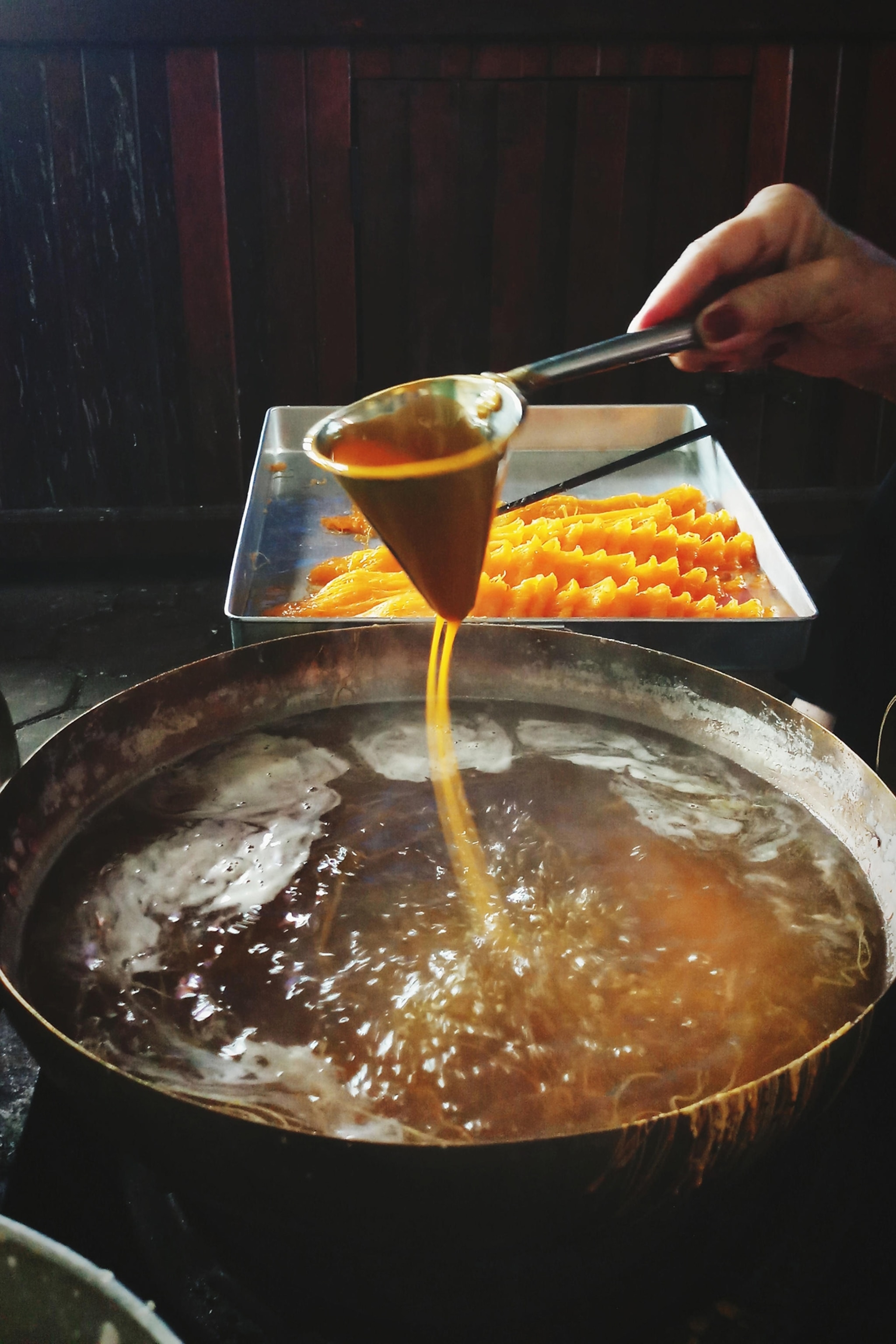 Hand are making of traditional Thai dessert, Foi Thong or Golden Egg strips.