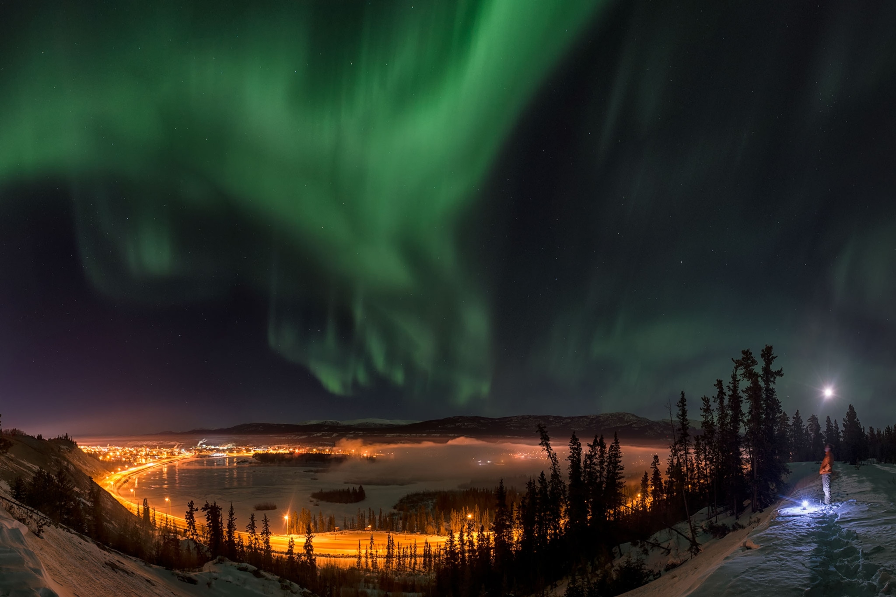 a person looking at the aurora borealis over Canada