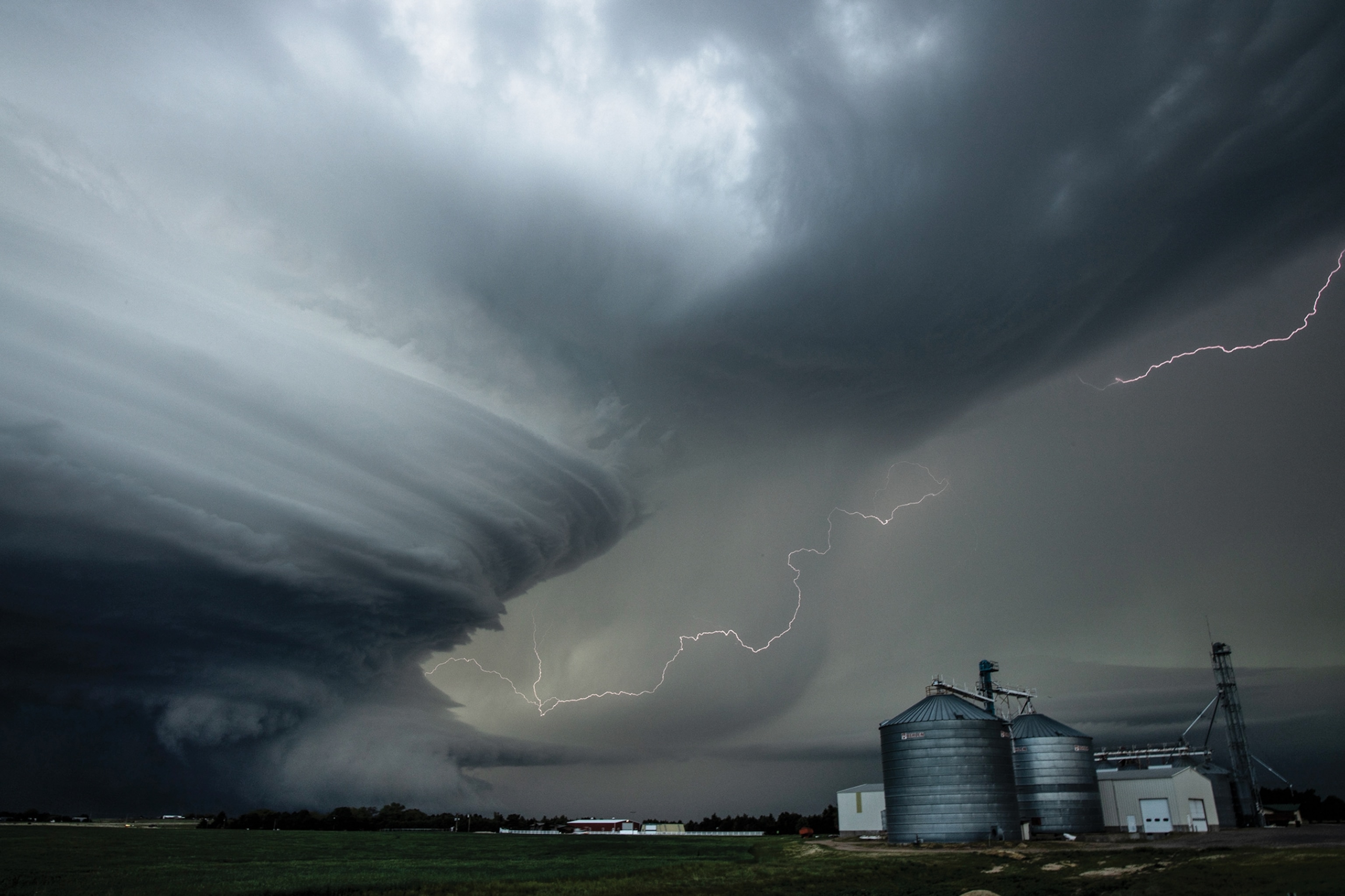 Storm towers over a farm grain elevator.