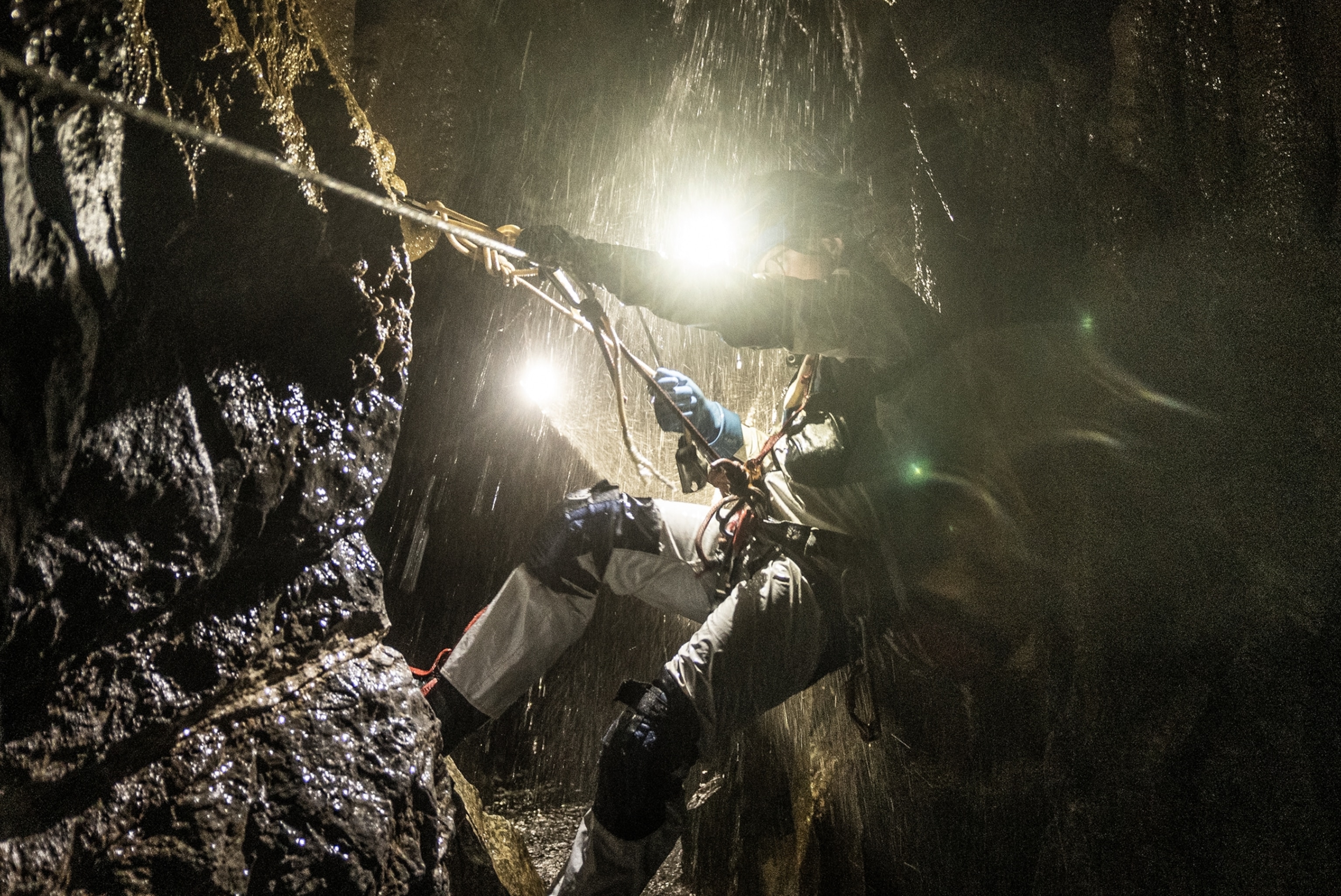 Picture of person climbing up against poring water.