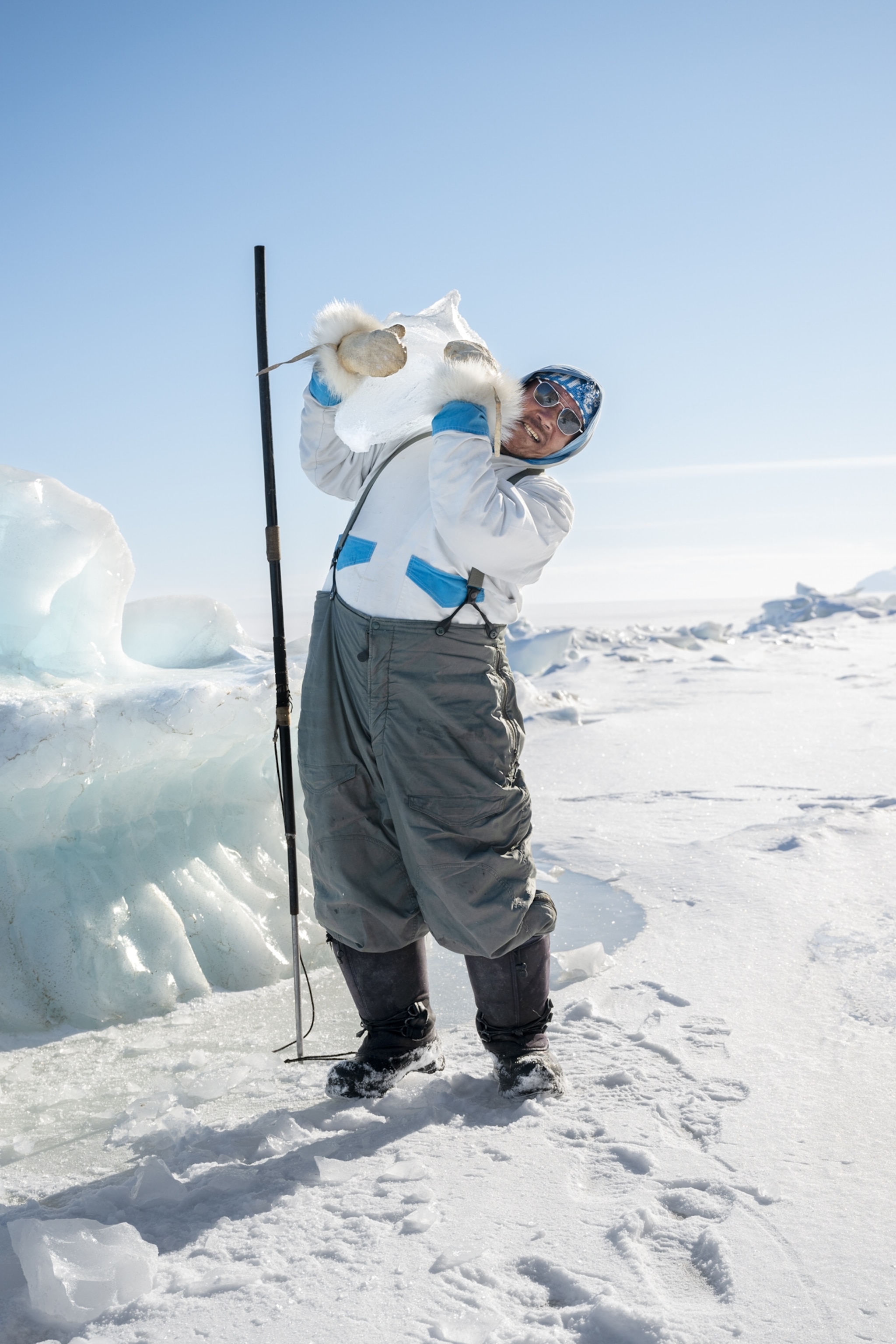 Ilannguaq Qaernaq shoulders a piece of an iceberg.