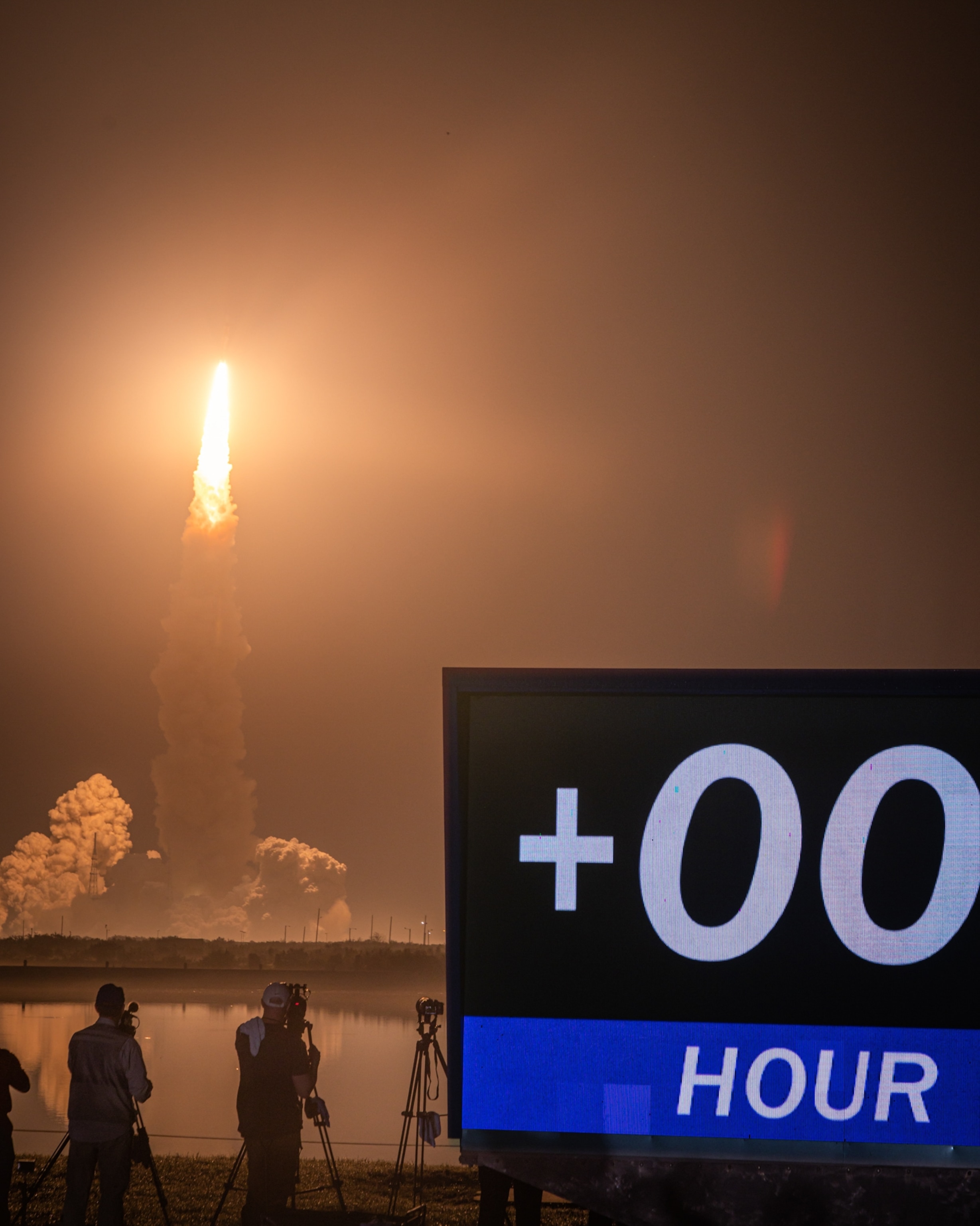 Artemis-1 launch photographed from the press site at Launch Complex 39, Kennedy Space Center, FL, with the countdown clock showing "+00"