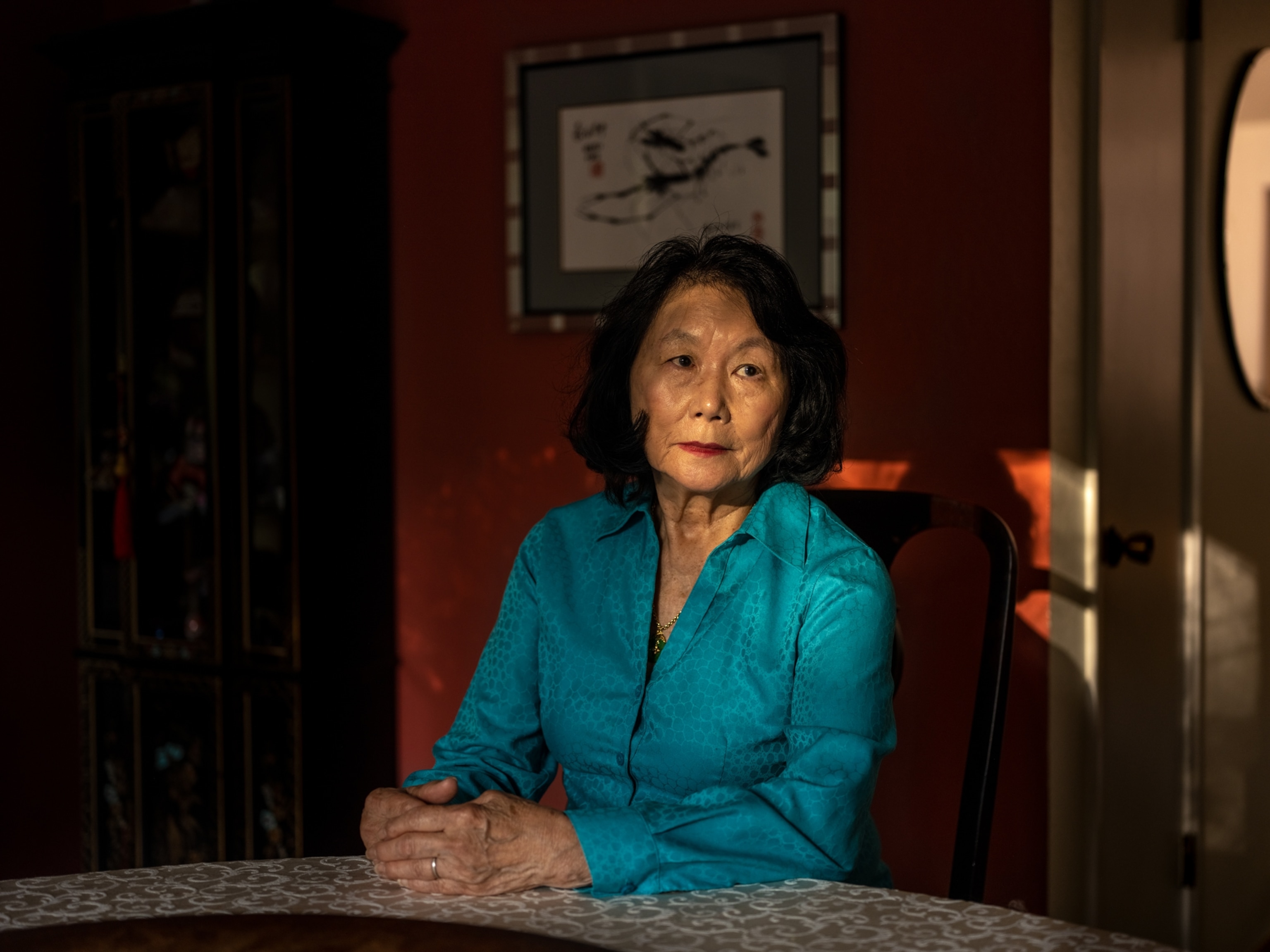 Connie Young Yu, 80, poses for a portrait by the table at her home.