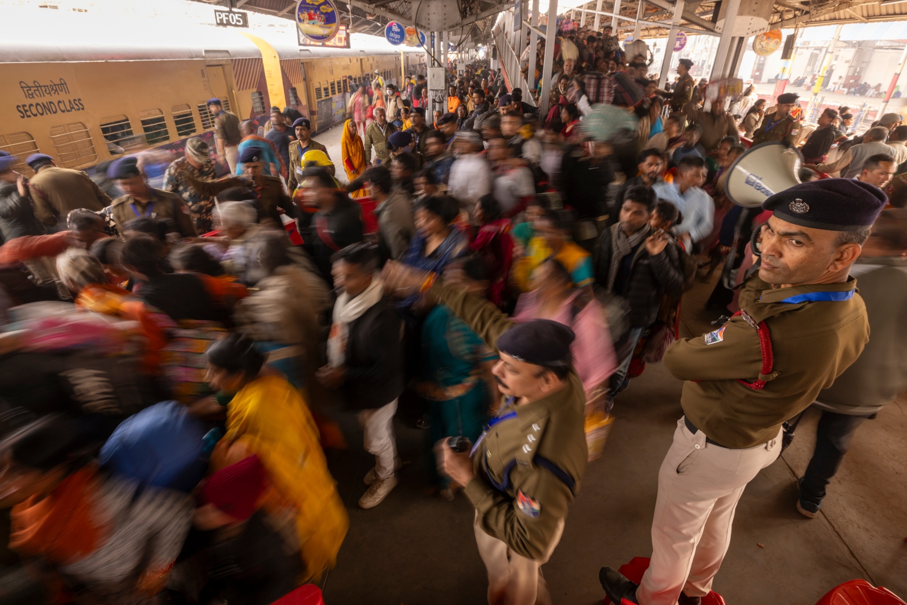 A crowd of people board a train.
