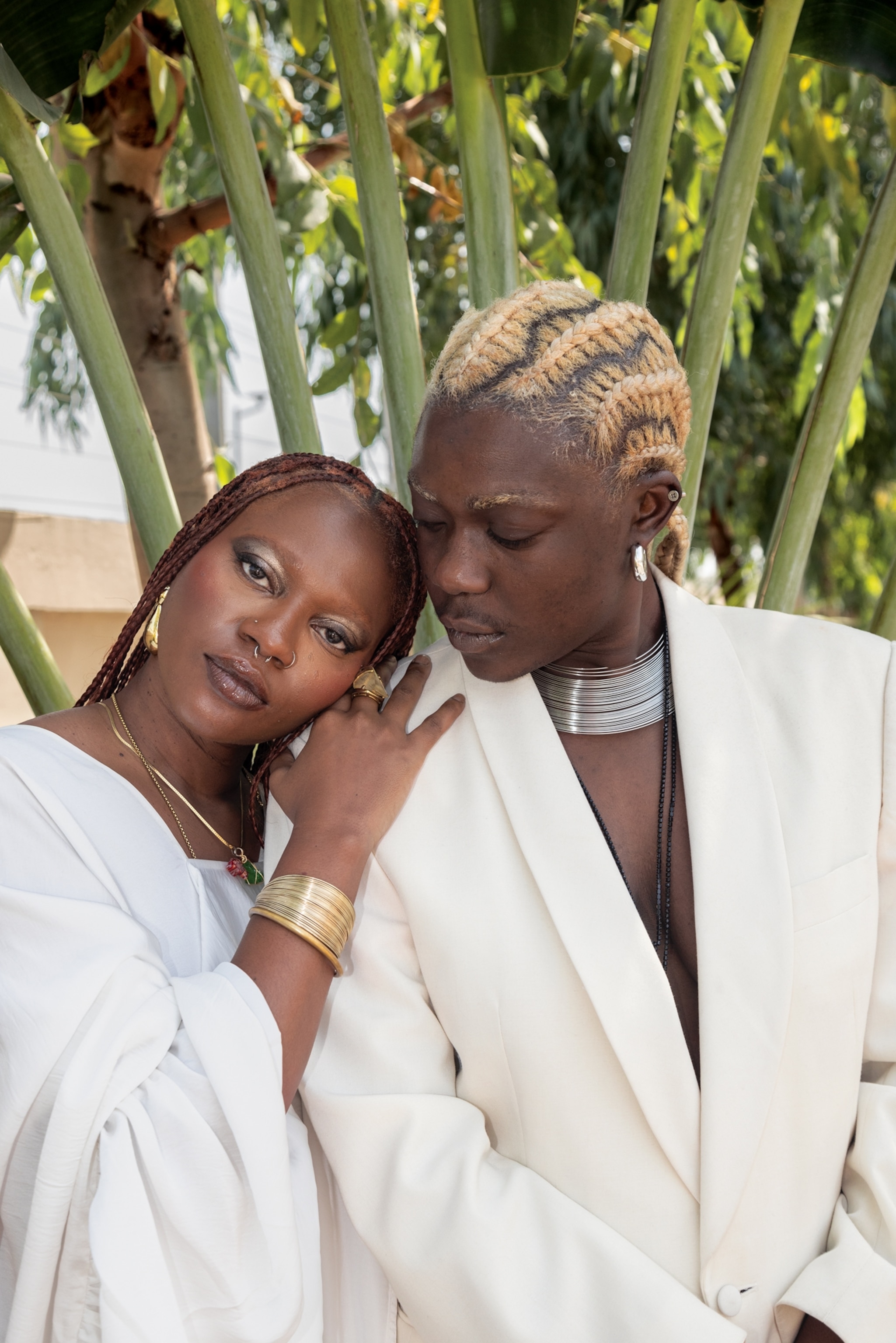 Portrait of Uyai Ikpe-Etim (left) resting on the shoulder of Ayo Lawson (right). They are wearing white.