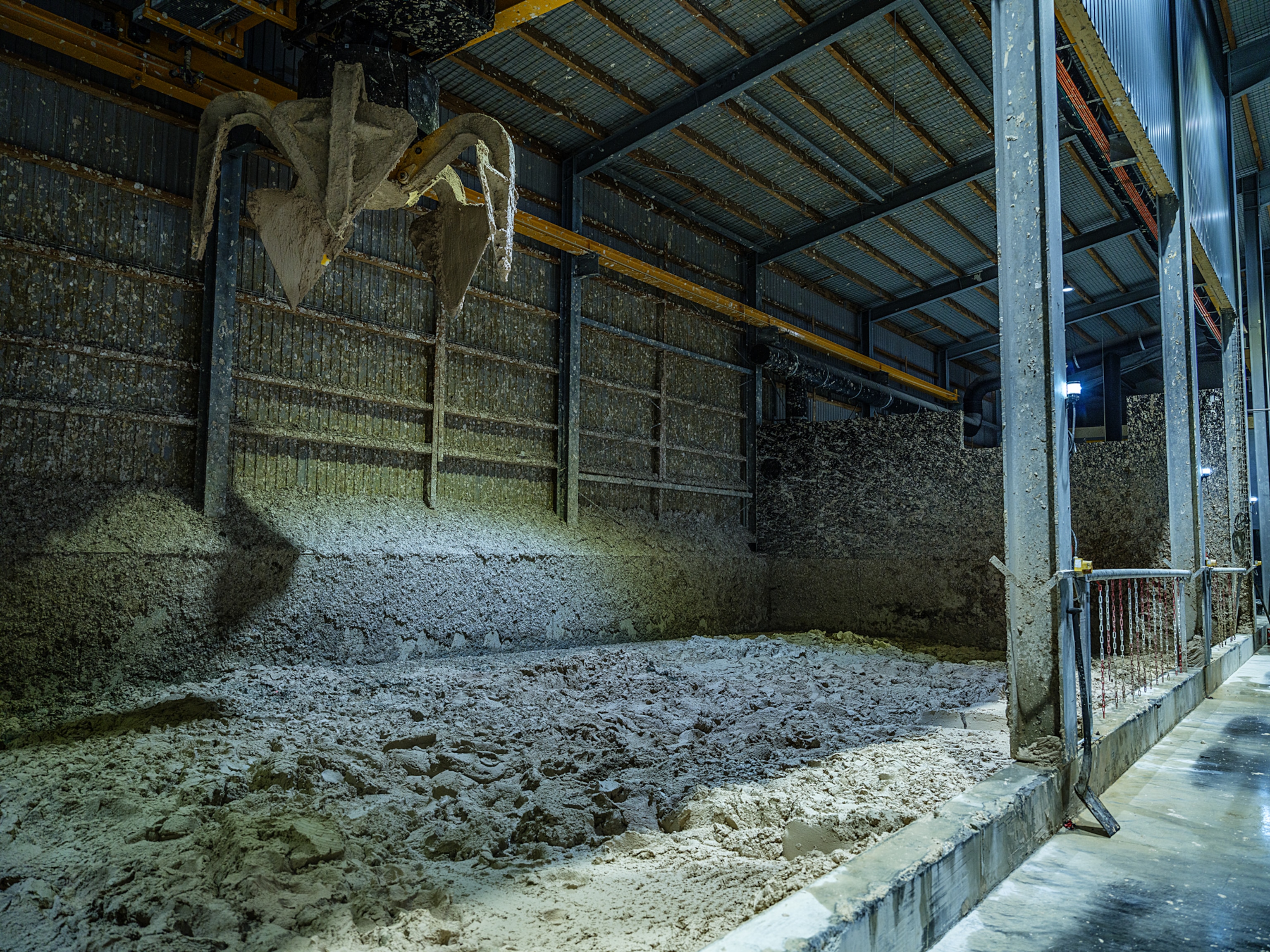 A large industrial claw covered in byproduct sludge