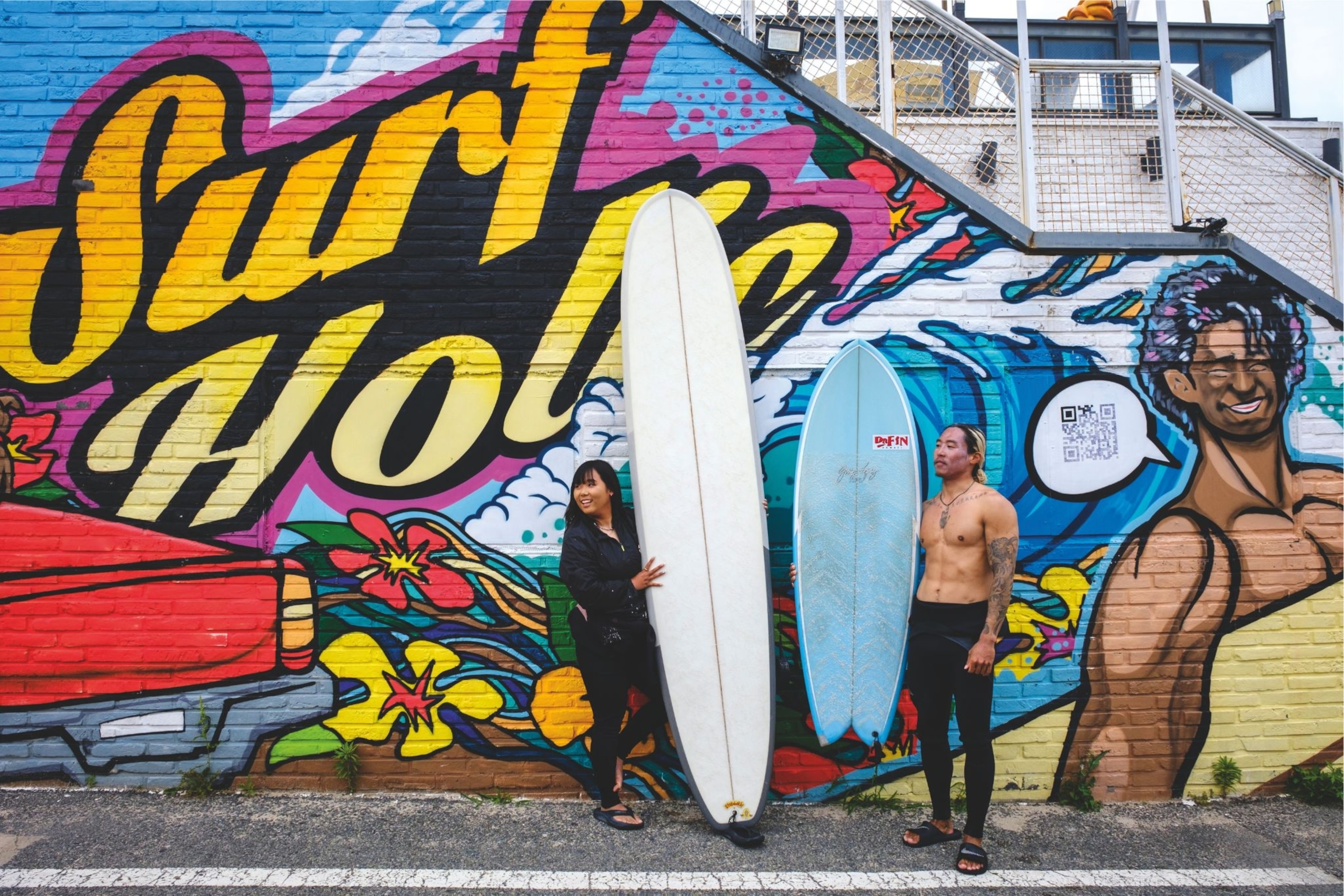 a man and woman with surf boards