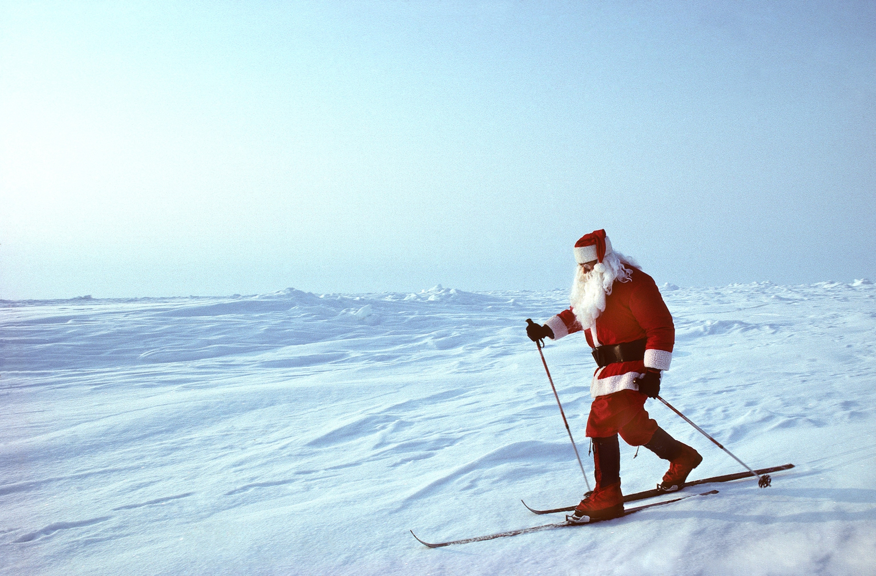 A skier dressed as Santa Claus stands at the true North Pole.