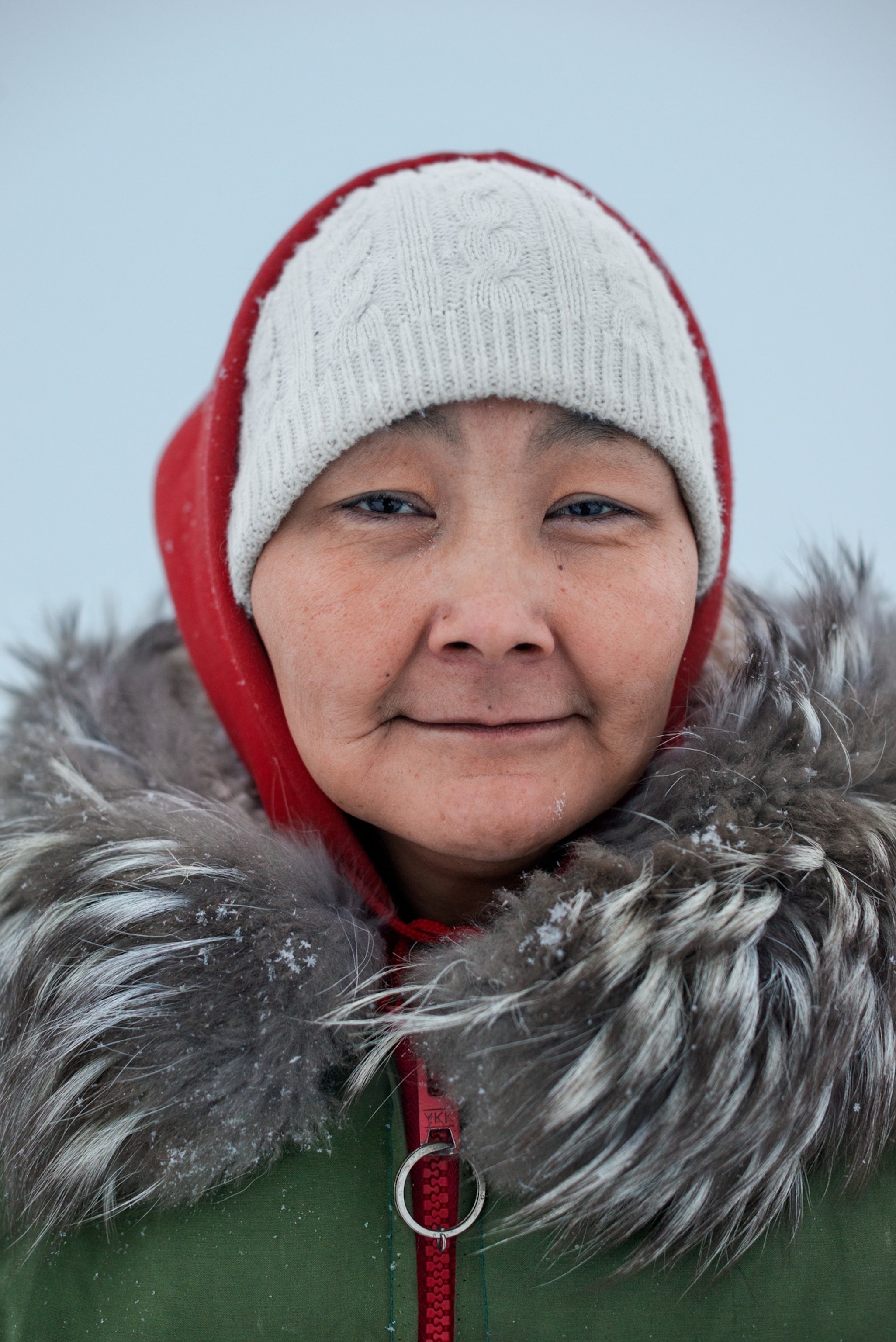 female Init ranger in green parka with fur.