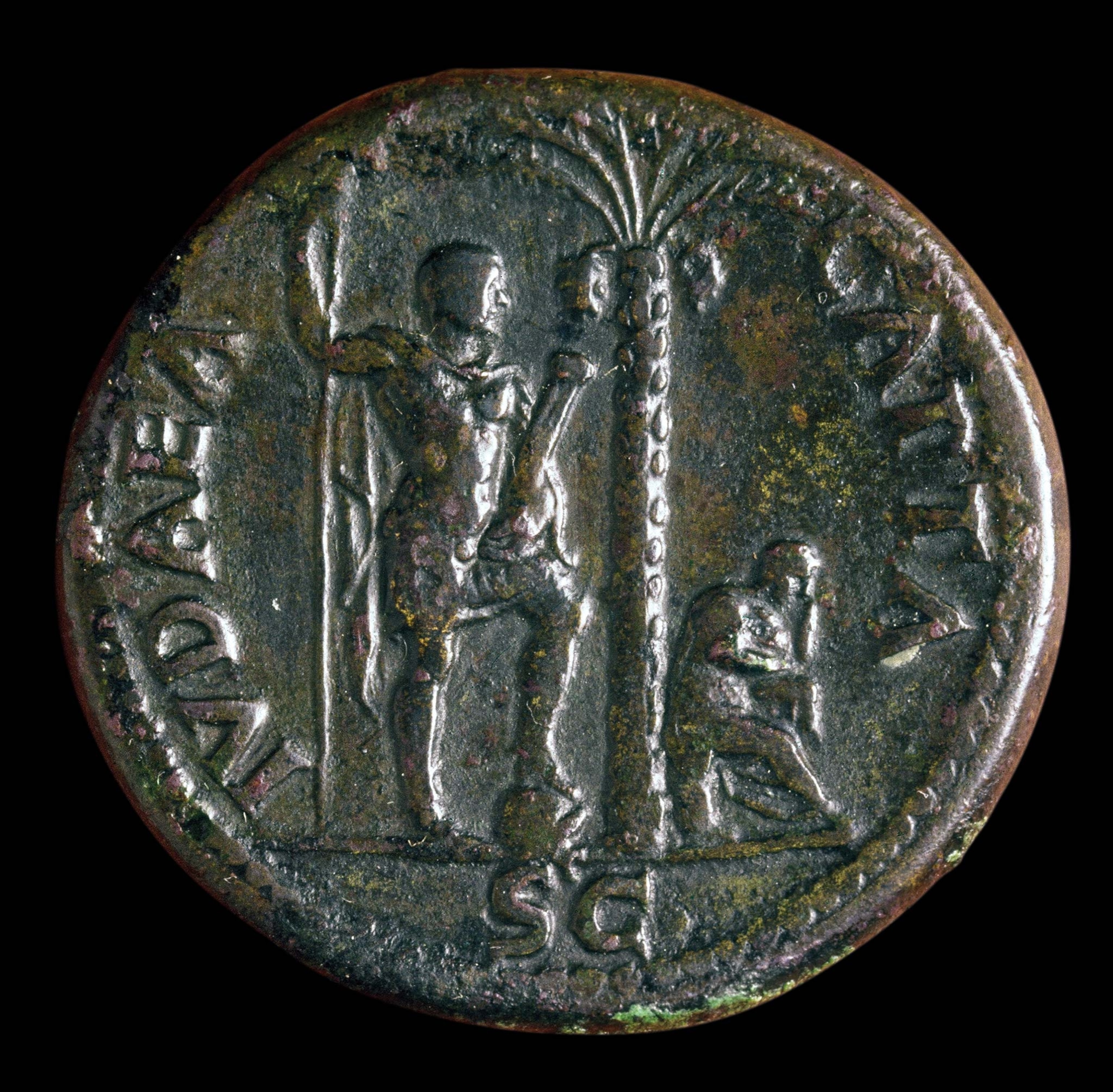 An old coin with two men and a tree center, the words Judea capta around the edge