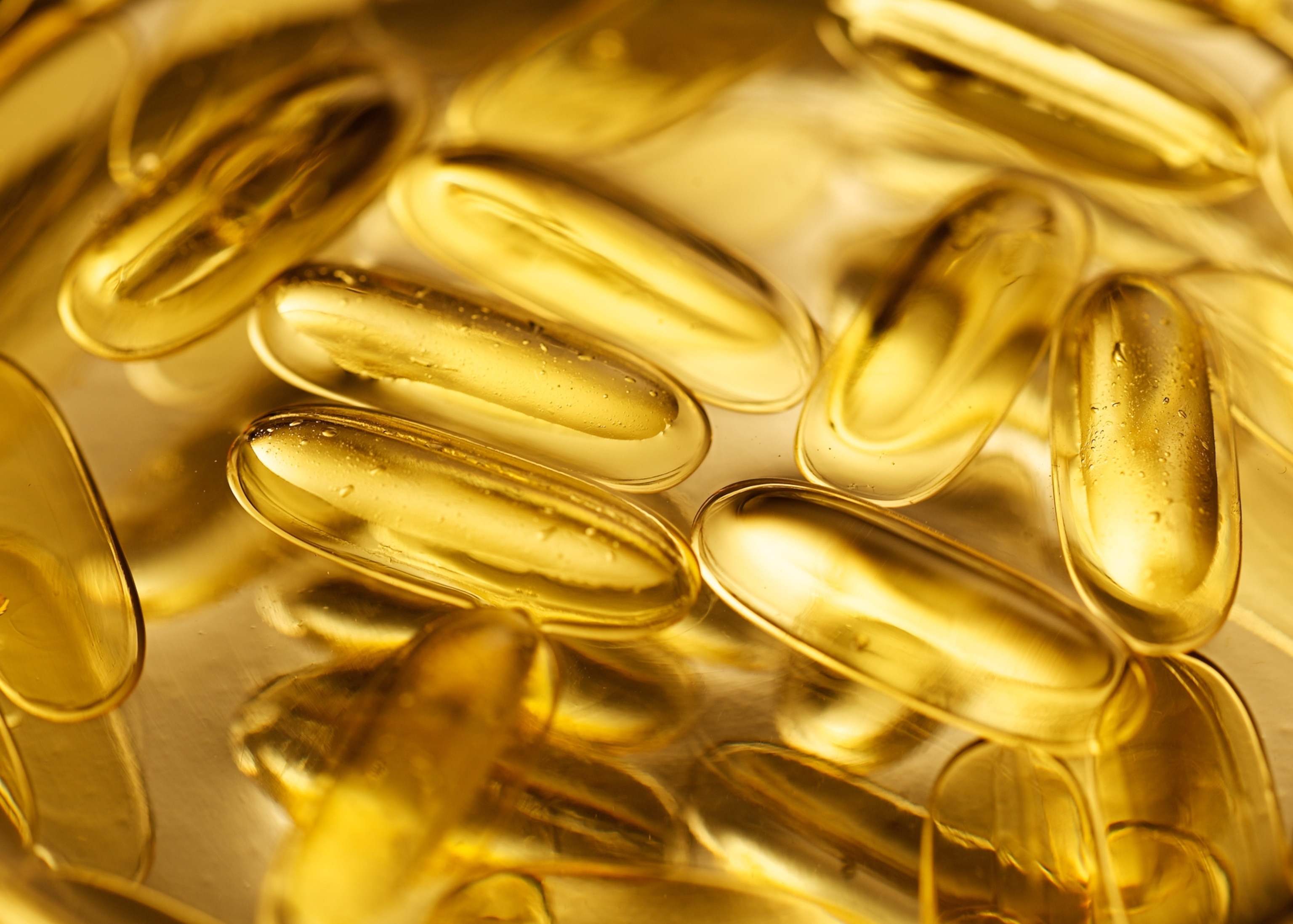 A close up view of golden yellow translucent gel capsules.