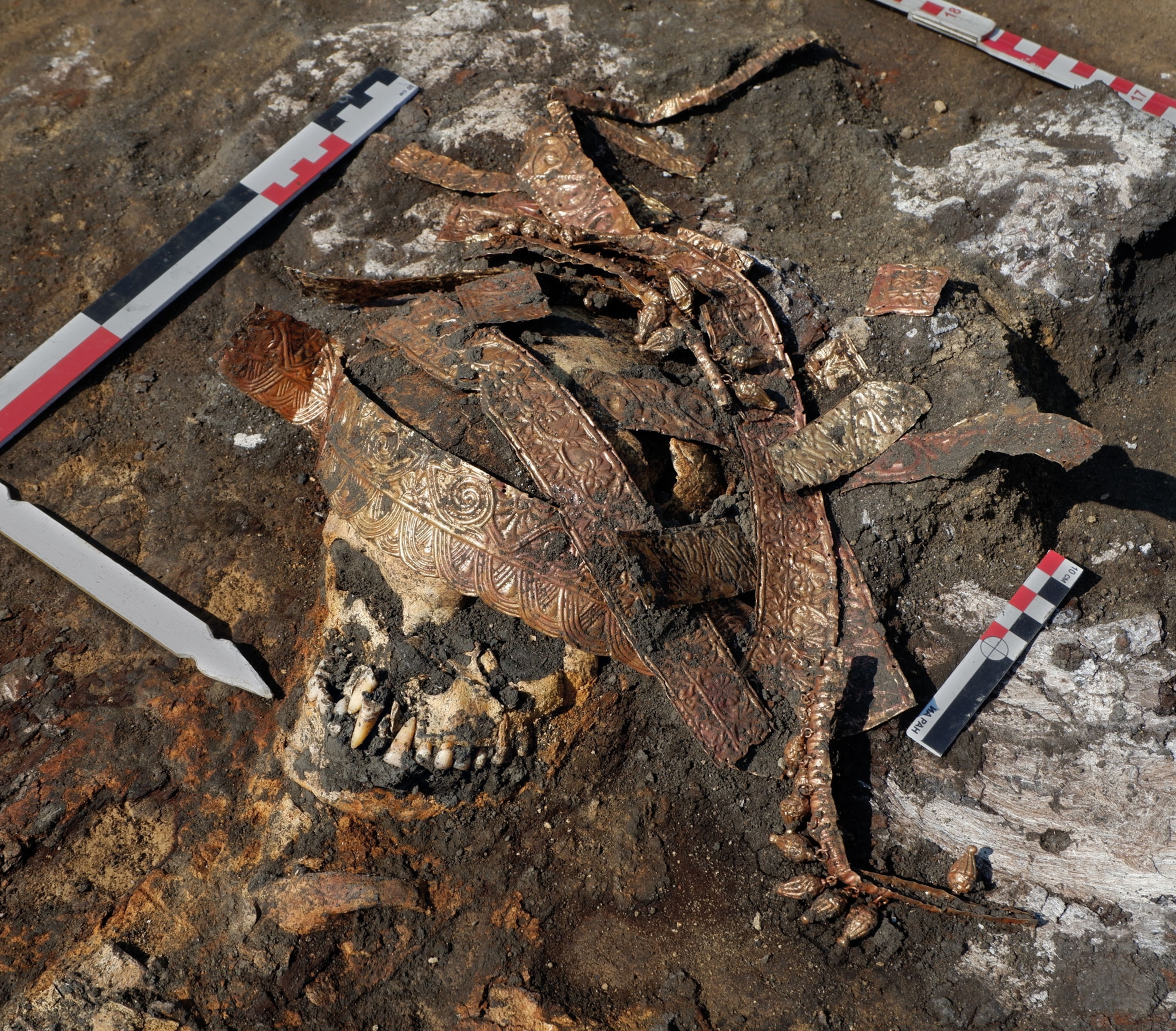 a skull in the mud with a headdress on