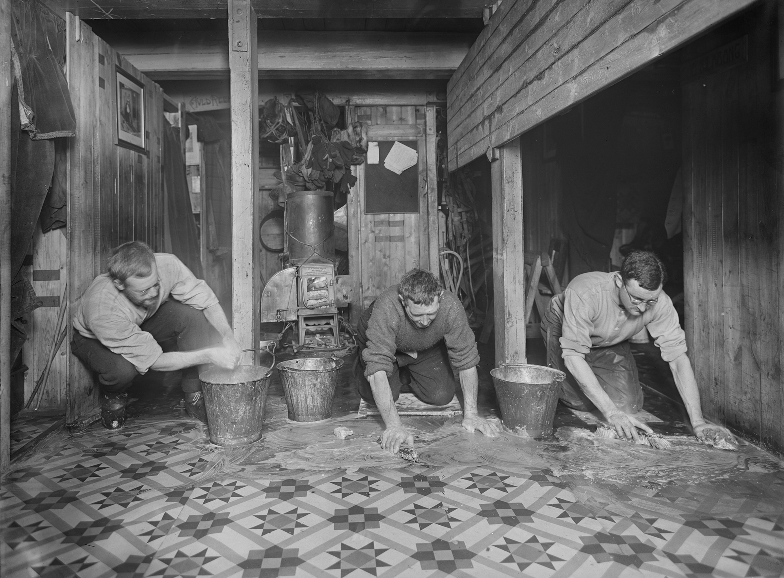 Members of Shackleton’s crew scrub the linoleum on board Endurance.
