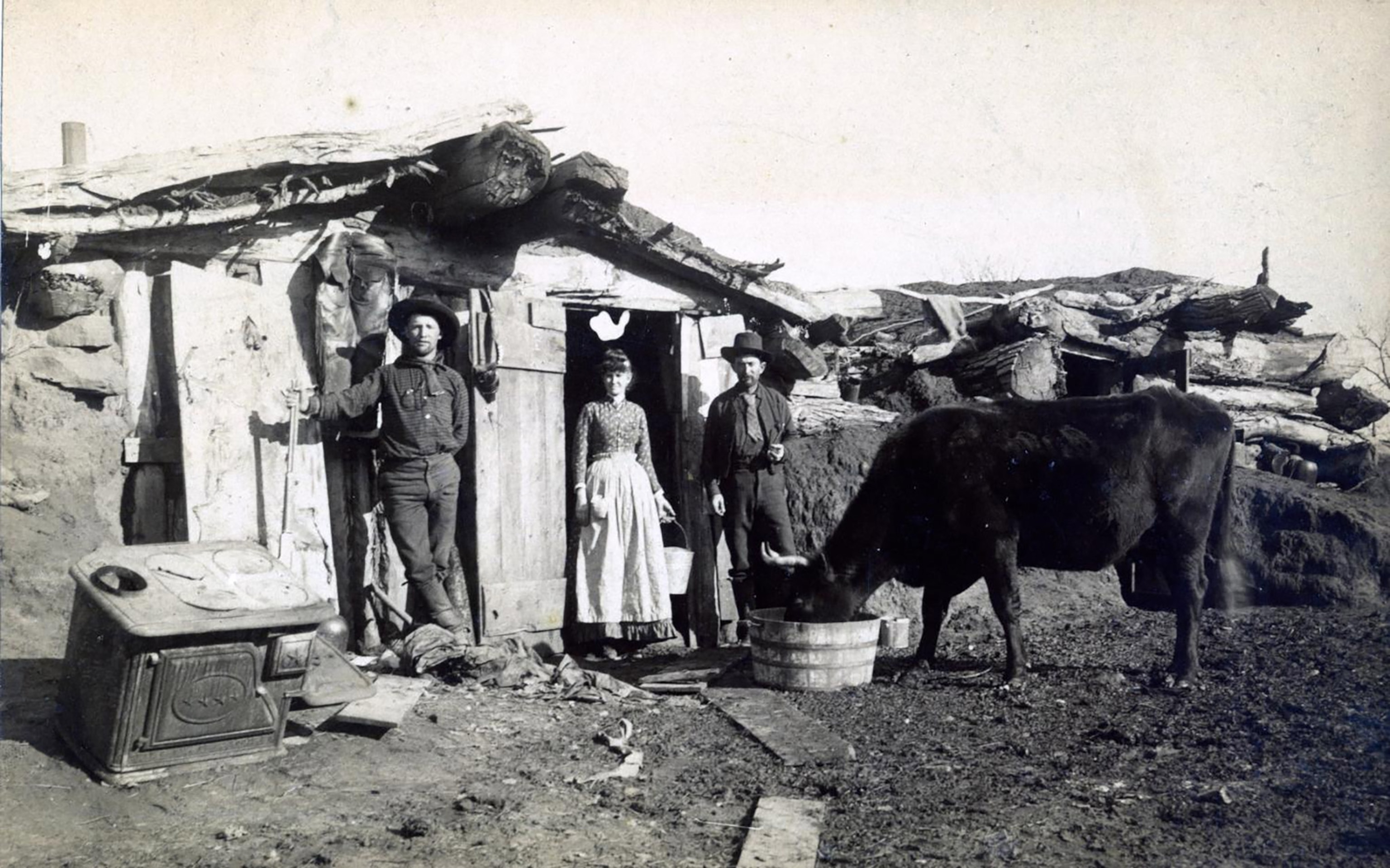 People stand in front of a shack.