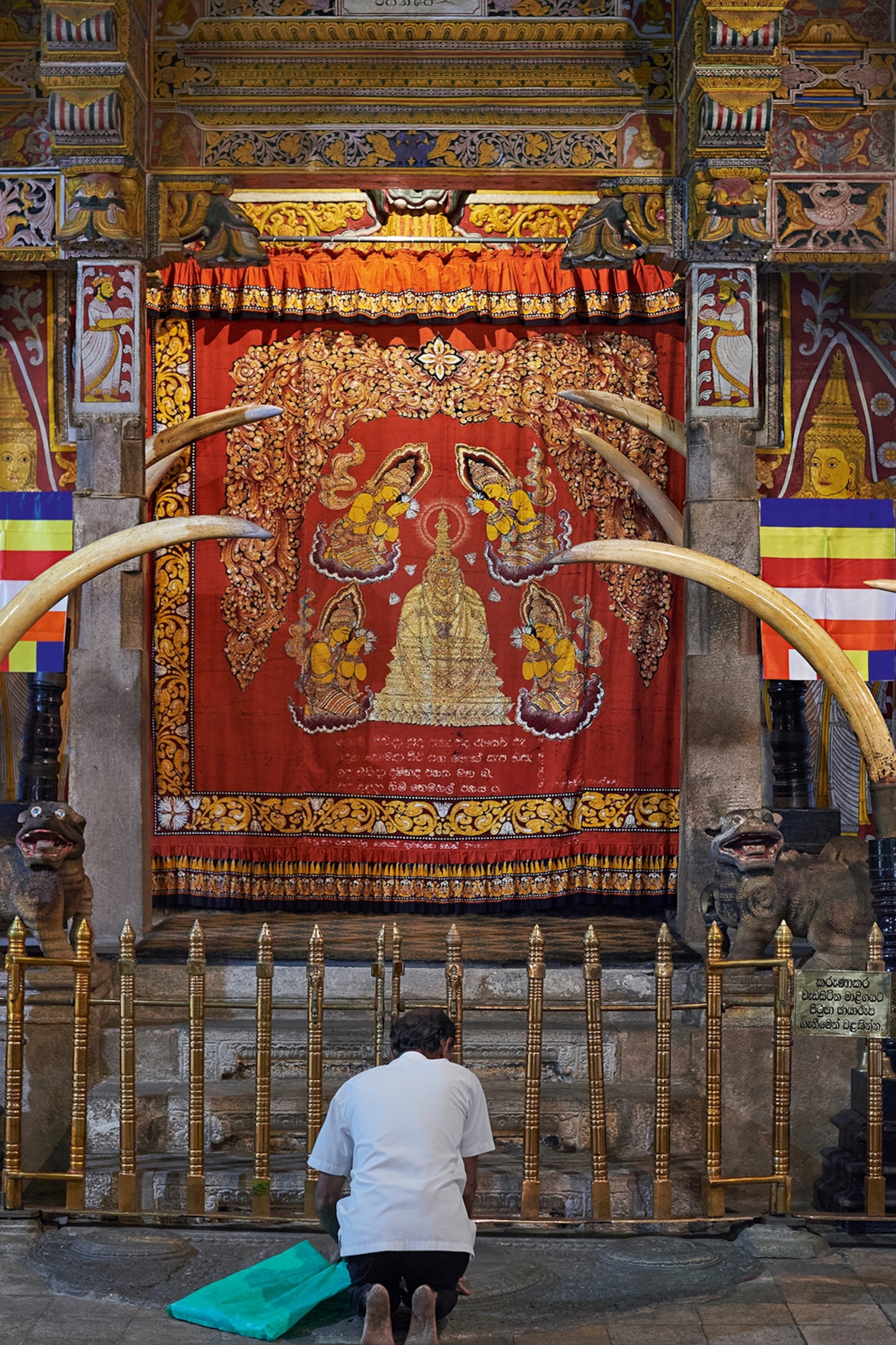 Man kneeling in front of a shrine in a temple