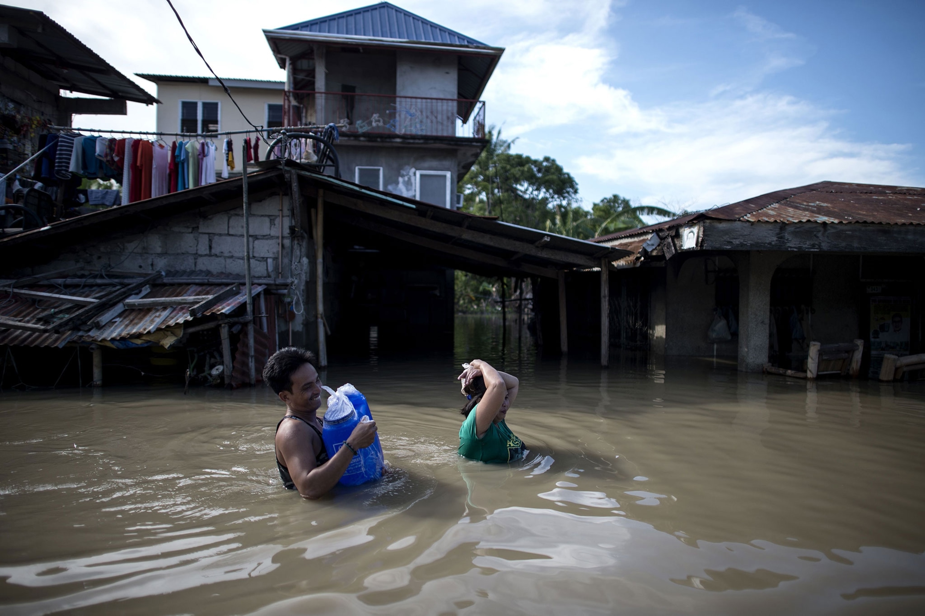 residents wading through the flooded streets of Calumpit, Bulacan in the Philippines.