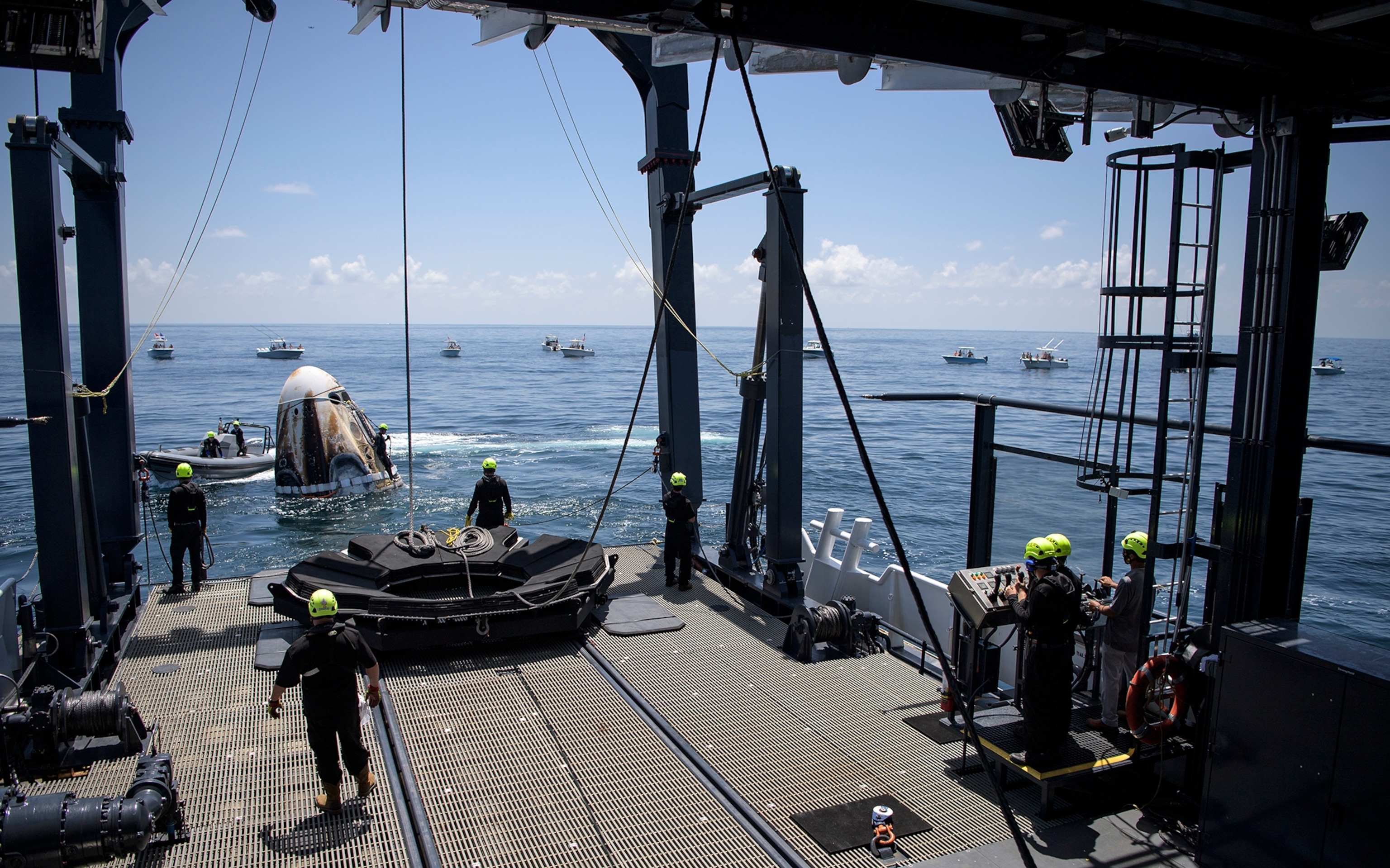 SPACEX Dragon capsule is hauled aboard ship after safe landing.