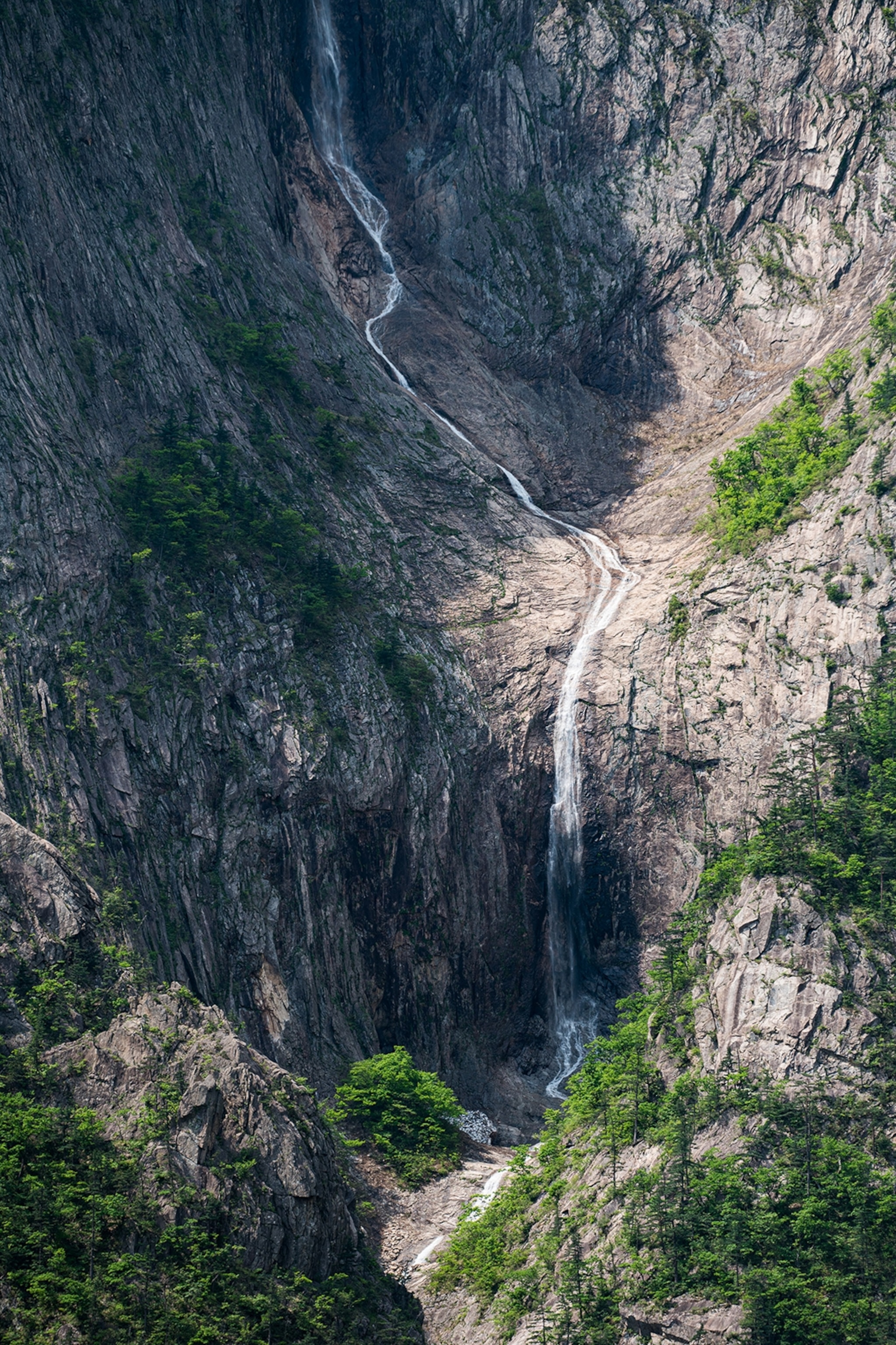Water running down the mountainside and falling to the ground in a waterfall