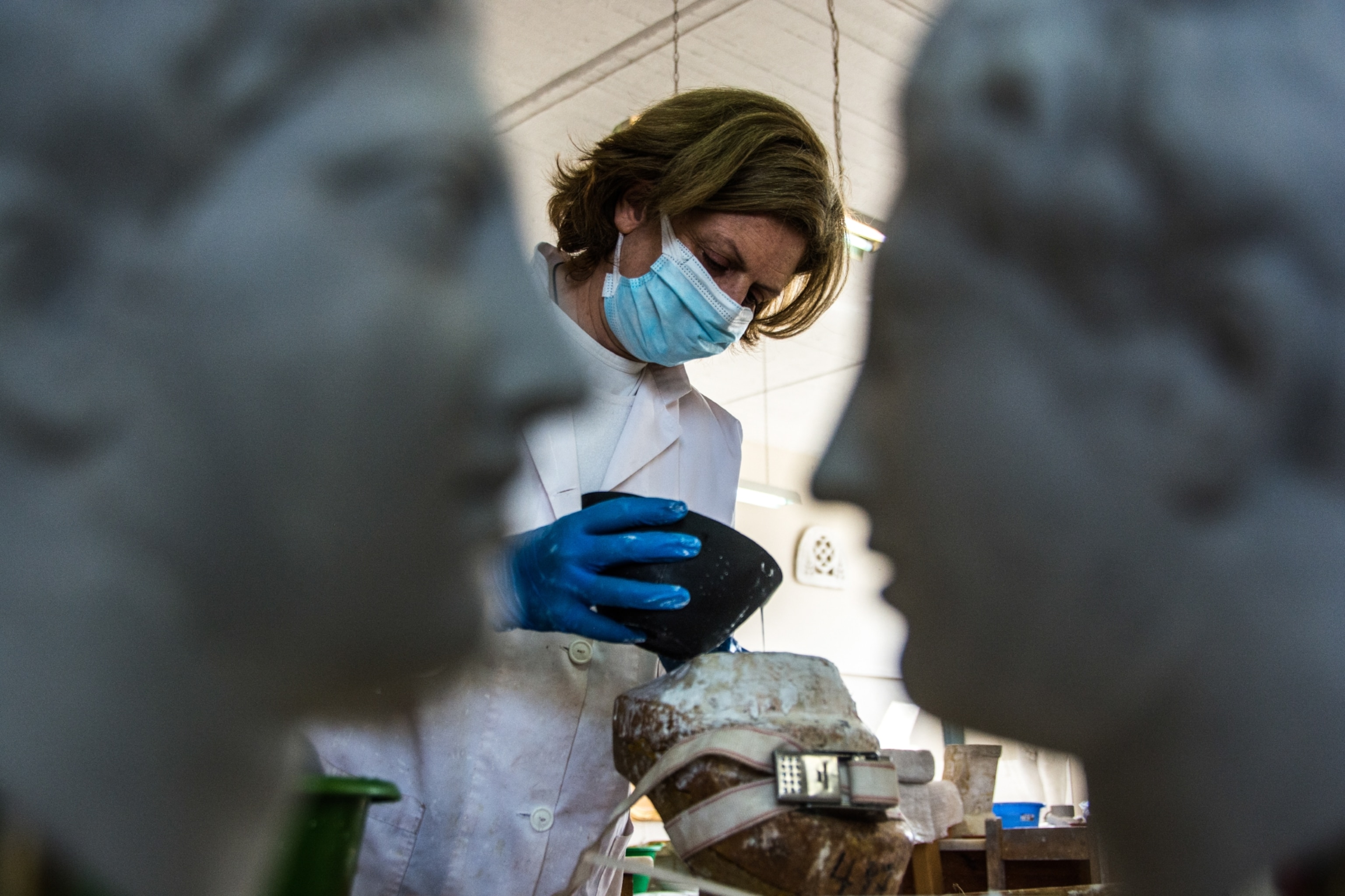 An artist pours a mixture into a mold