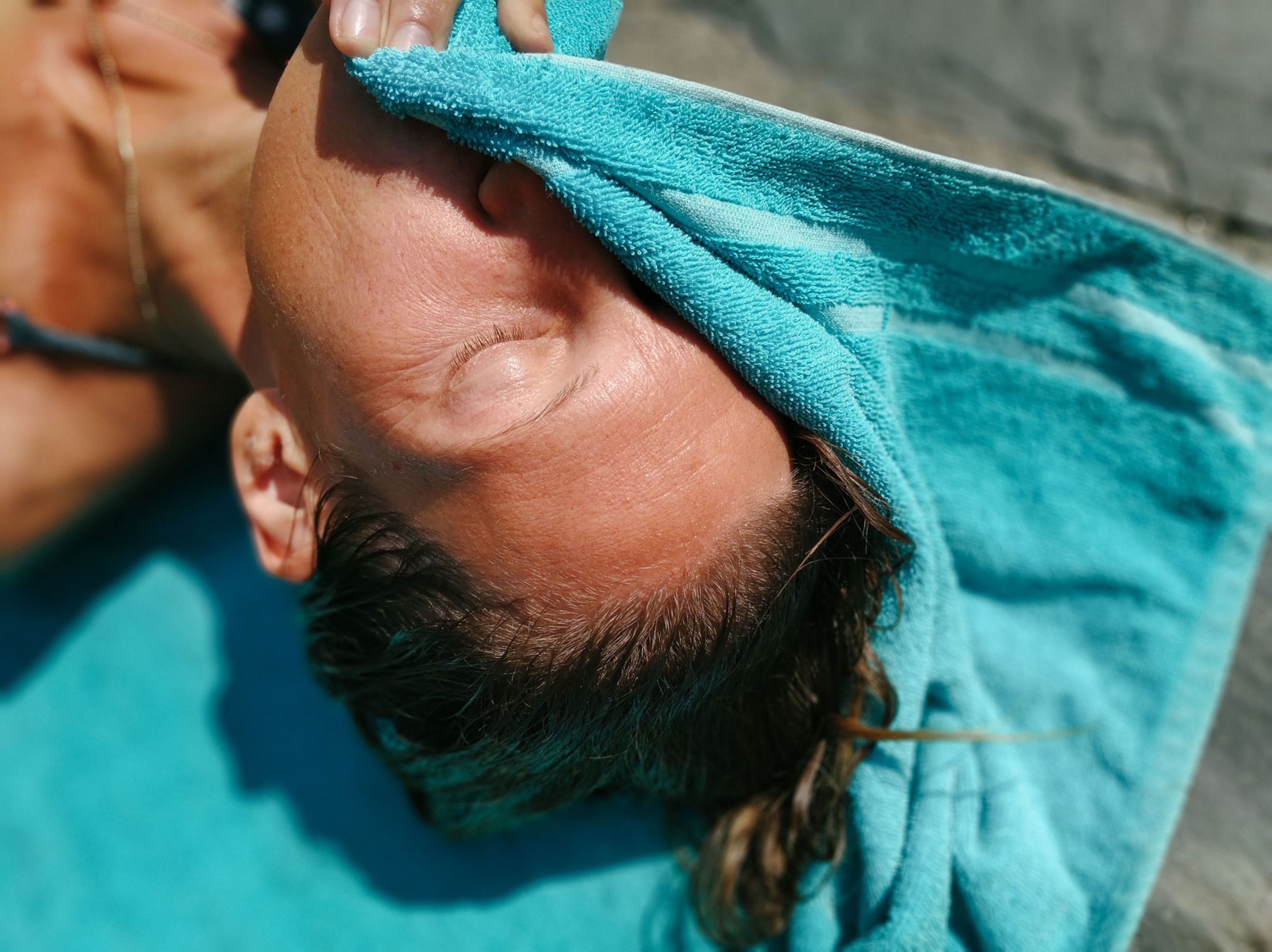 a woman on a blue towel in the sun